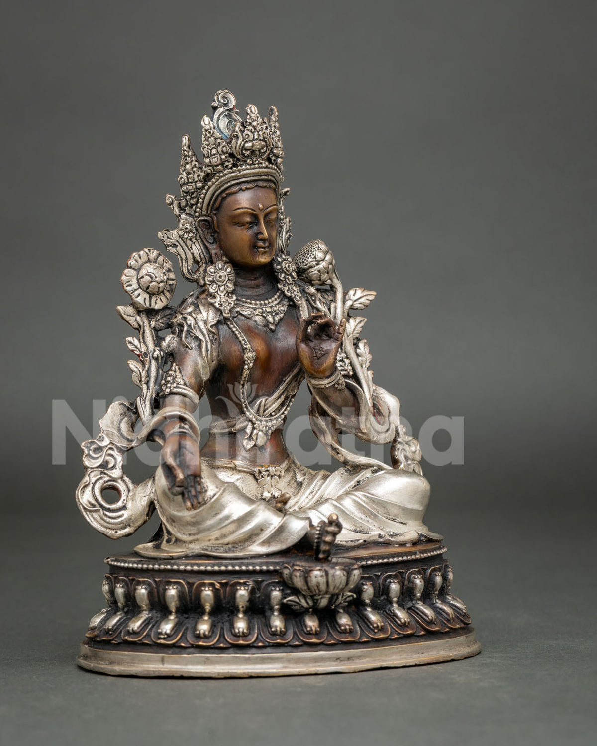 Three-quarter side view of seated Green Tara copper statue with oxidized brown patina