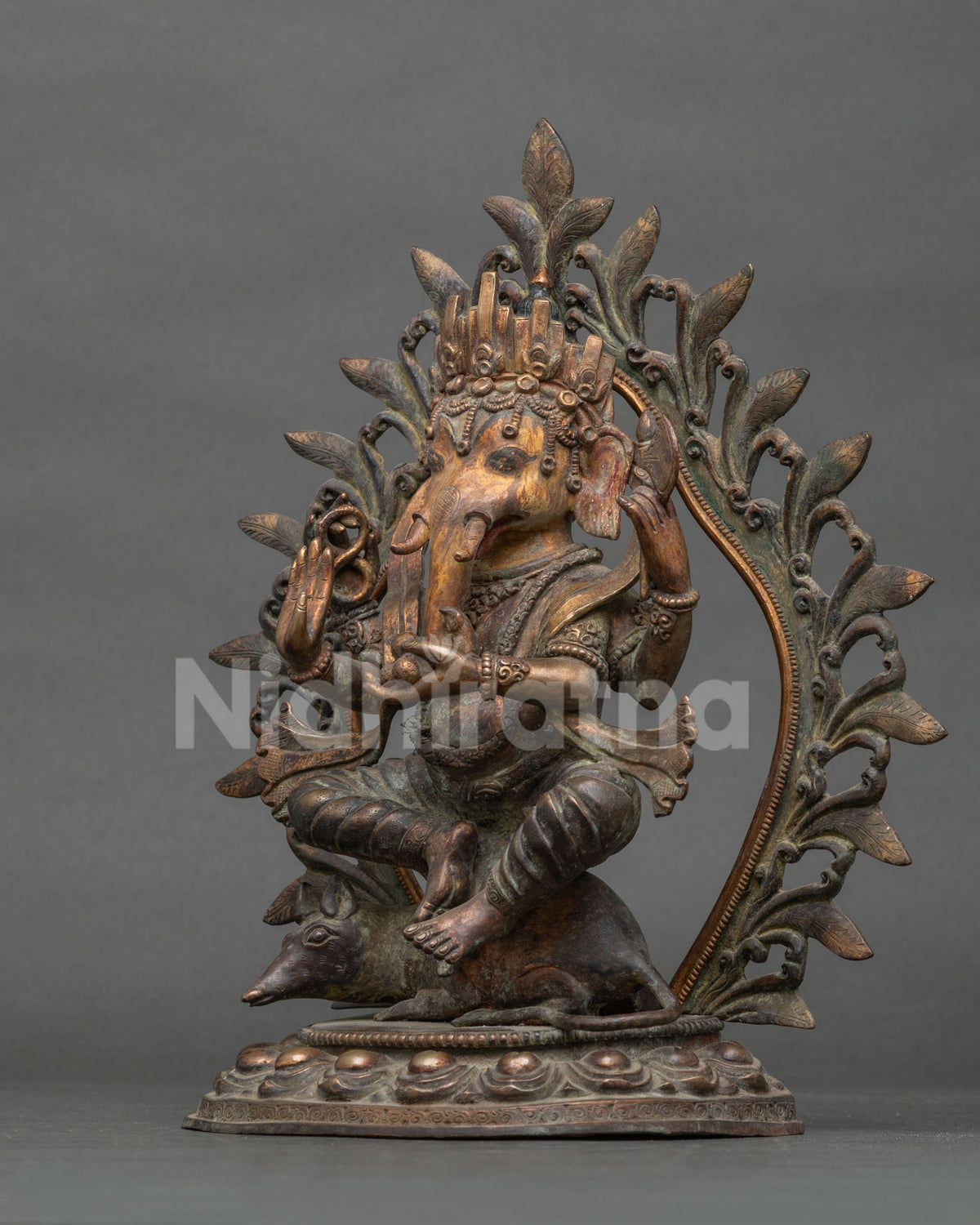 Three-quarter view of Four-armed Ganesh statue from Nepal with lotus base and Mushaka rat