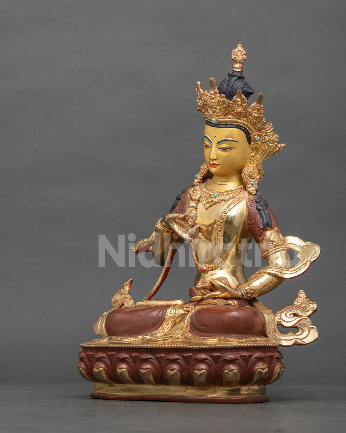 Three-quarter view of Vajrasattva statue holding vajra and ghanta on lotus base