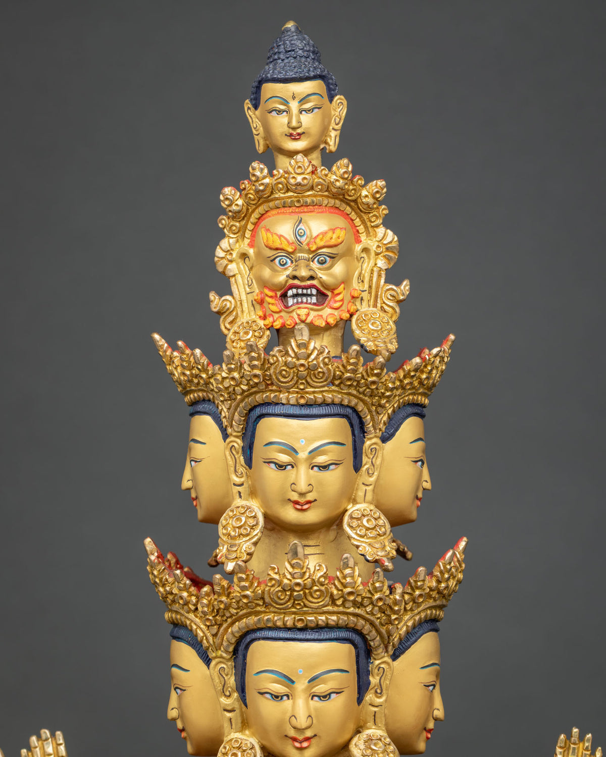 Tiered eleven heads of Chenrezig statue with peaceful faces, wrathful head and Buddha head on top