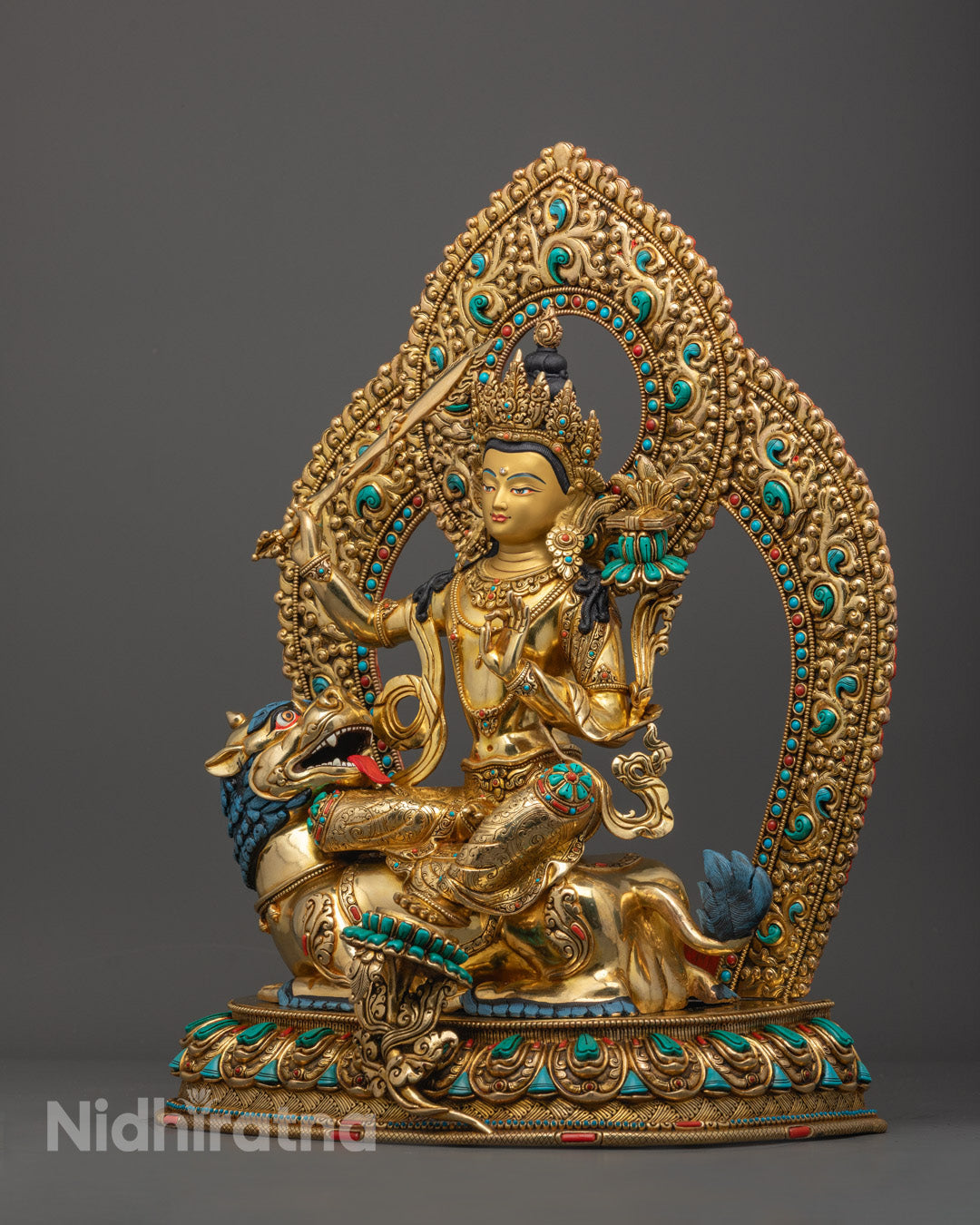 traditional Tibetan Manjushri deity statue showing intricate robe details, vajra-handled sword, and semi-precious stone inlays.