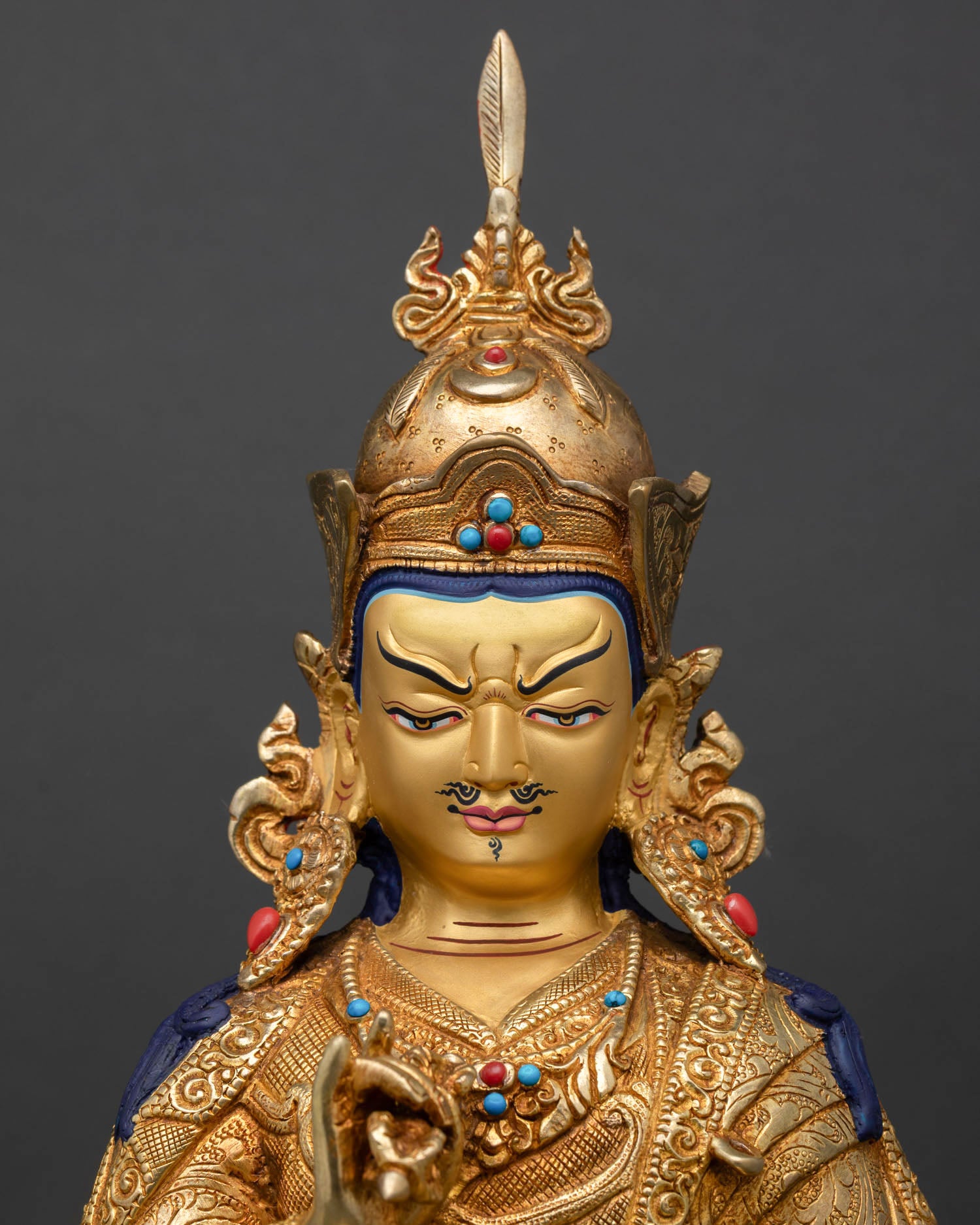 Tsokye Dorje face close up gold painted expression semi precious stone inlays intricate Himalayan craftsmanship details
