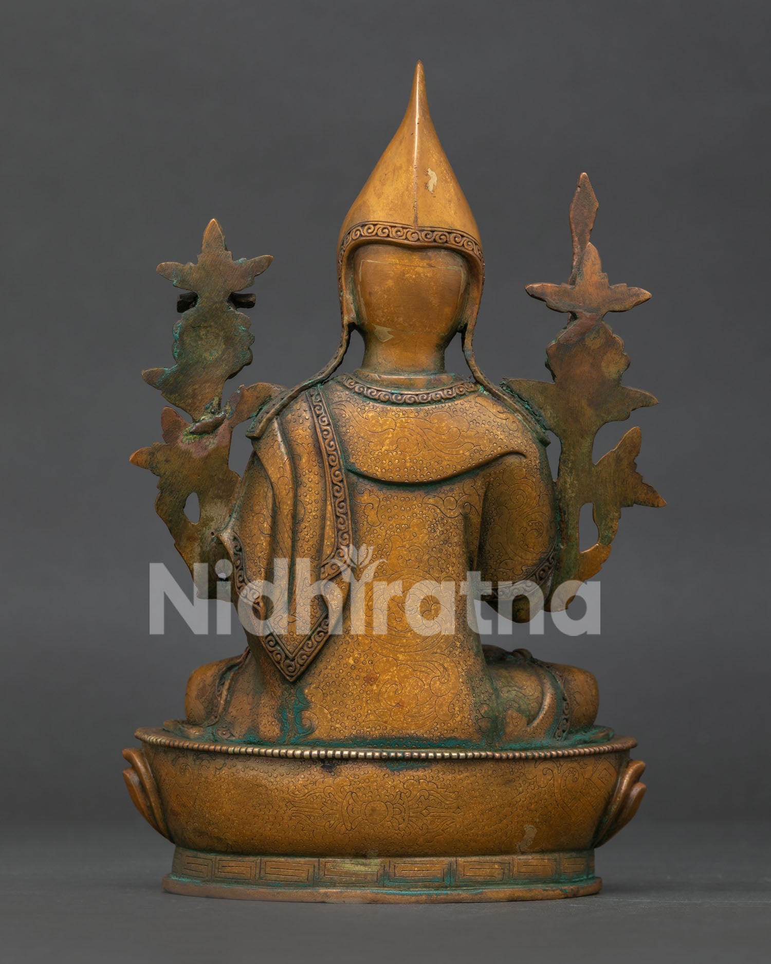 Tsongkhapa statue detailed view with lotus pedestal wisdom sword scripture and floral monastic robes.