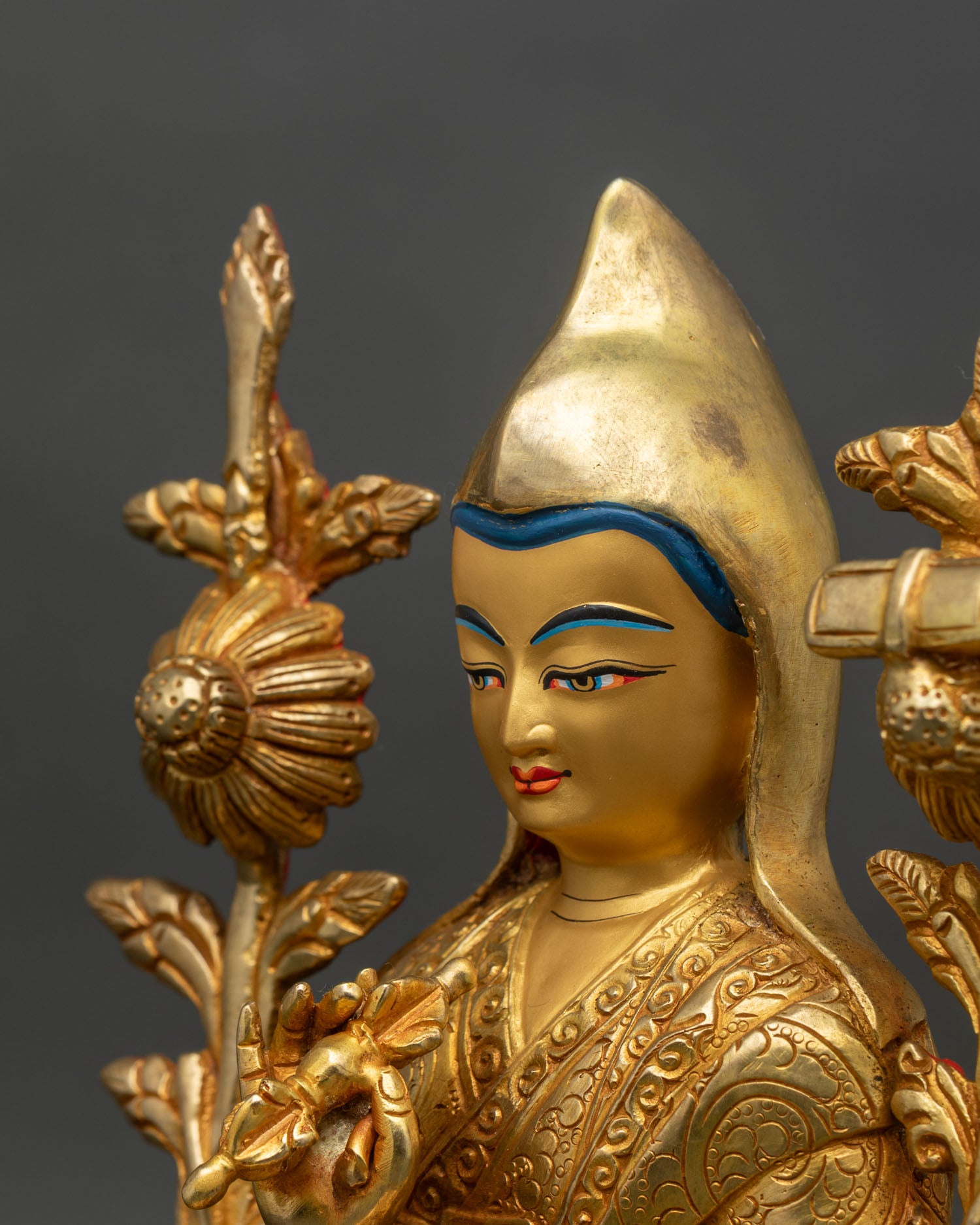 side detail of tsongkhapa statue showing engraved monastic robes and dharmachakra mudra