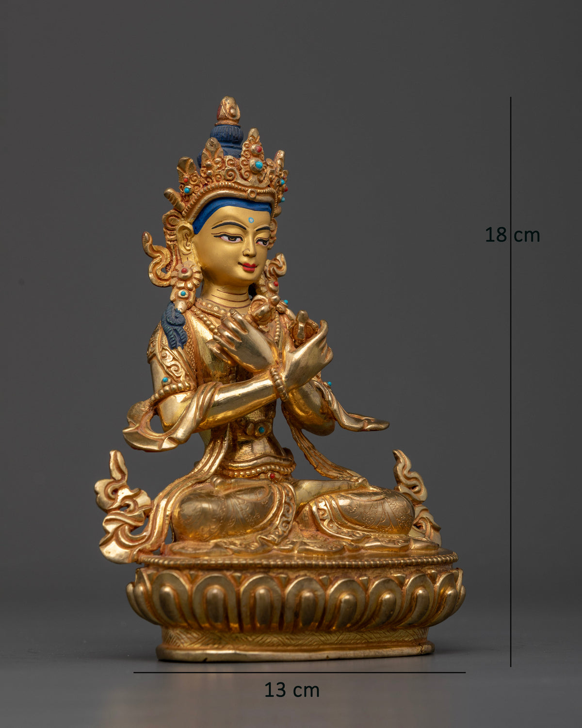 Vajradhara Buddha seated on a lotus pedestal holding a vajra and bell with arms crossed at the heart