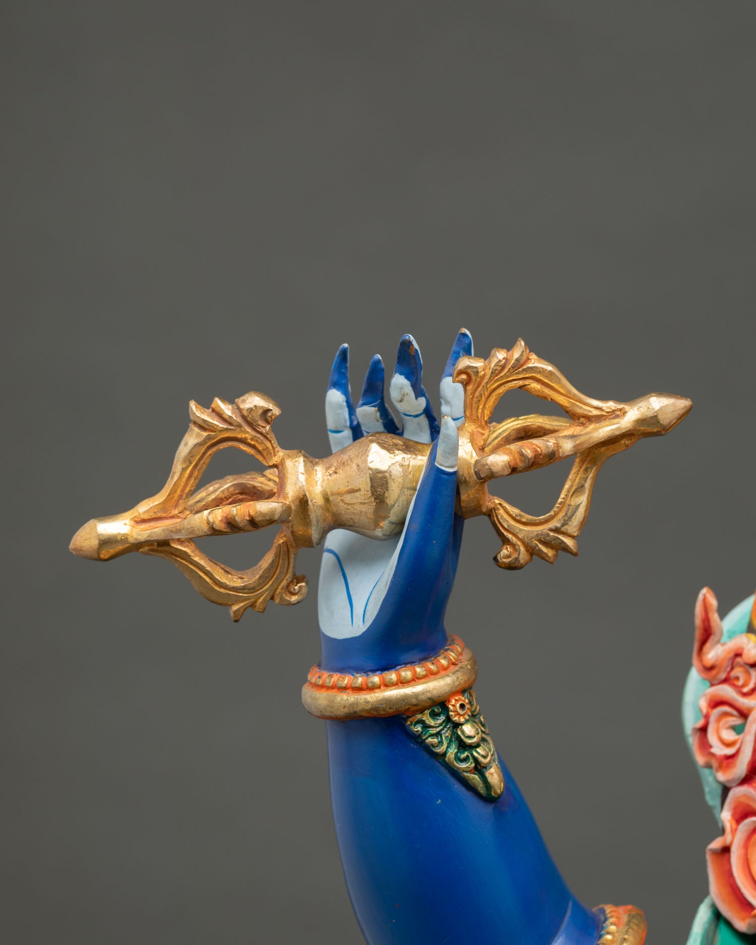 Vajrapani Bodhisattva statue holding gold-gilded vajra thunderbolt in right hand, symbol of overcoming obstacles