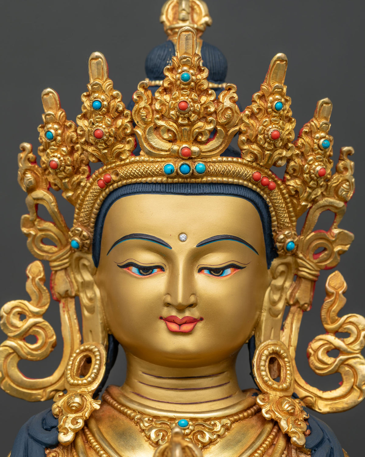 Vajrasattva Buddha statue face close up 24K gold painted face five jeweled crown.