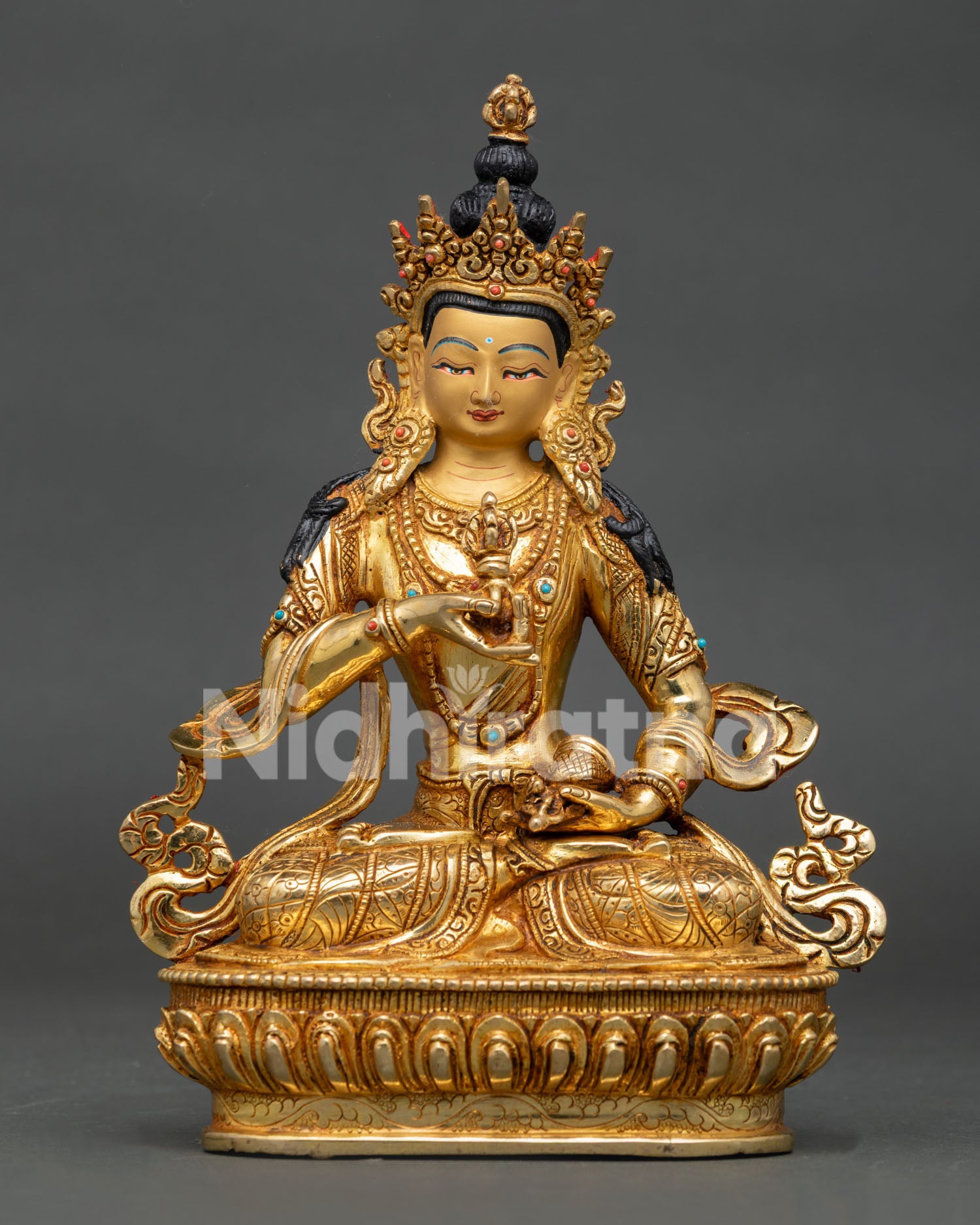 Vajrasattva Buddha statue holding five pronged vajra and bell on lotus pedestal.