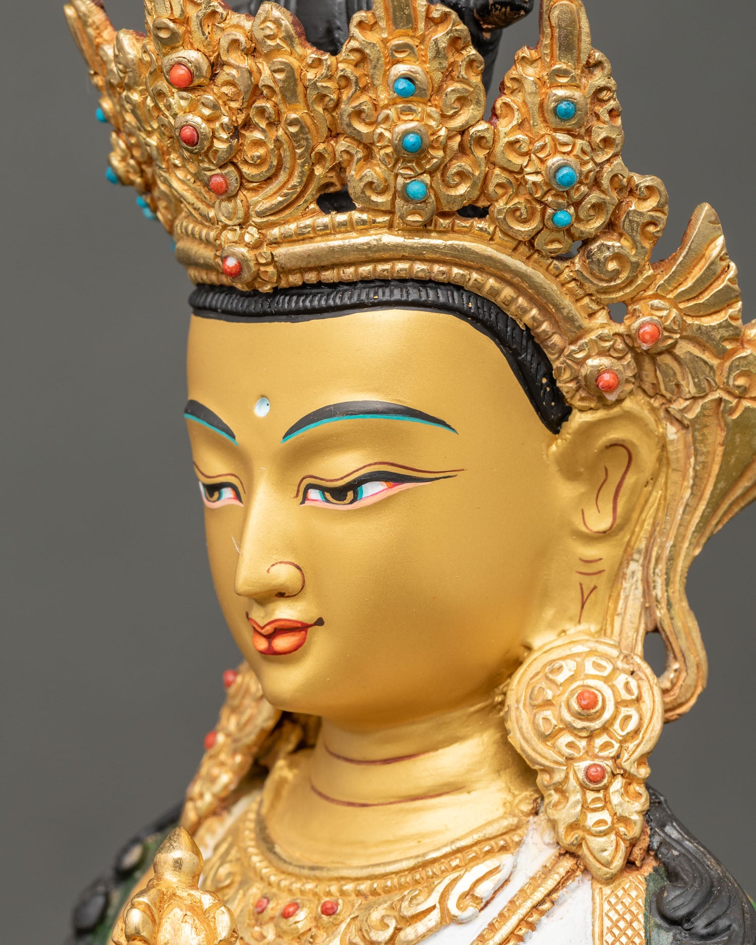 vajrasattva statue detailed side close up face, gold-painted features and sacred expression