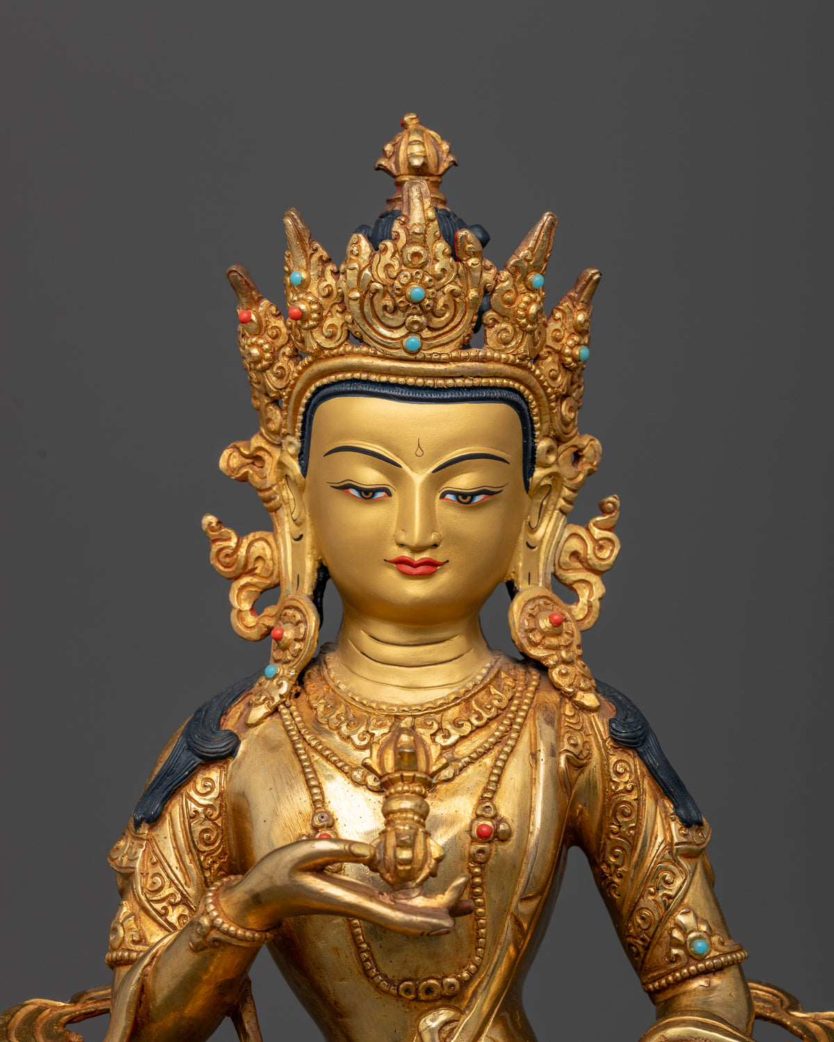 Vajrasattva Statue face close up 24K gold painted face ornate crown.