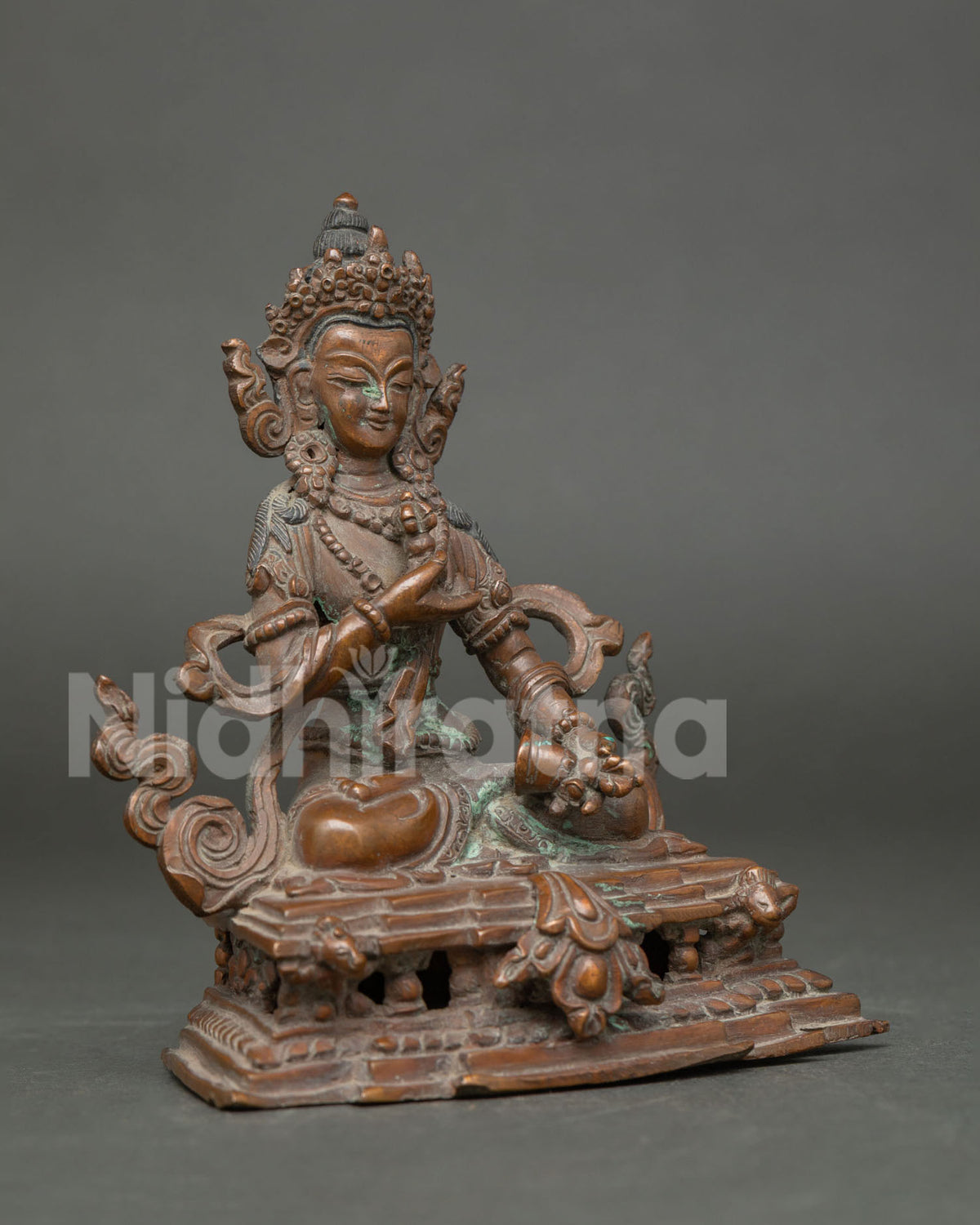 Vajrasattva statue holding five pronged vajra and ritual bell side view.