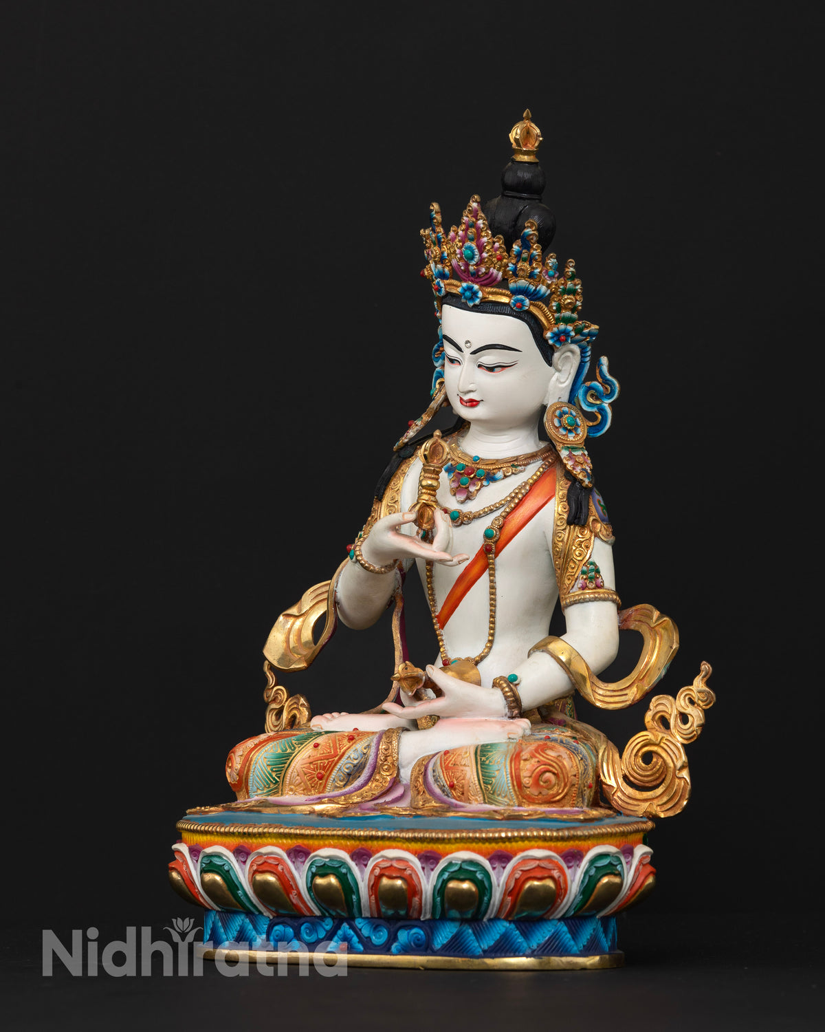 Vajrasattva statue seated on a lotus pedestal holding a vajra and bell symbolizing wisdom and compassion