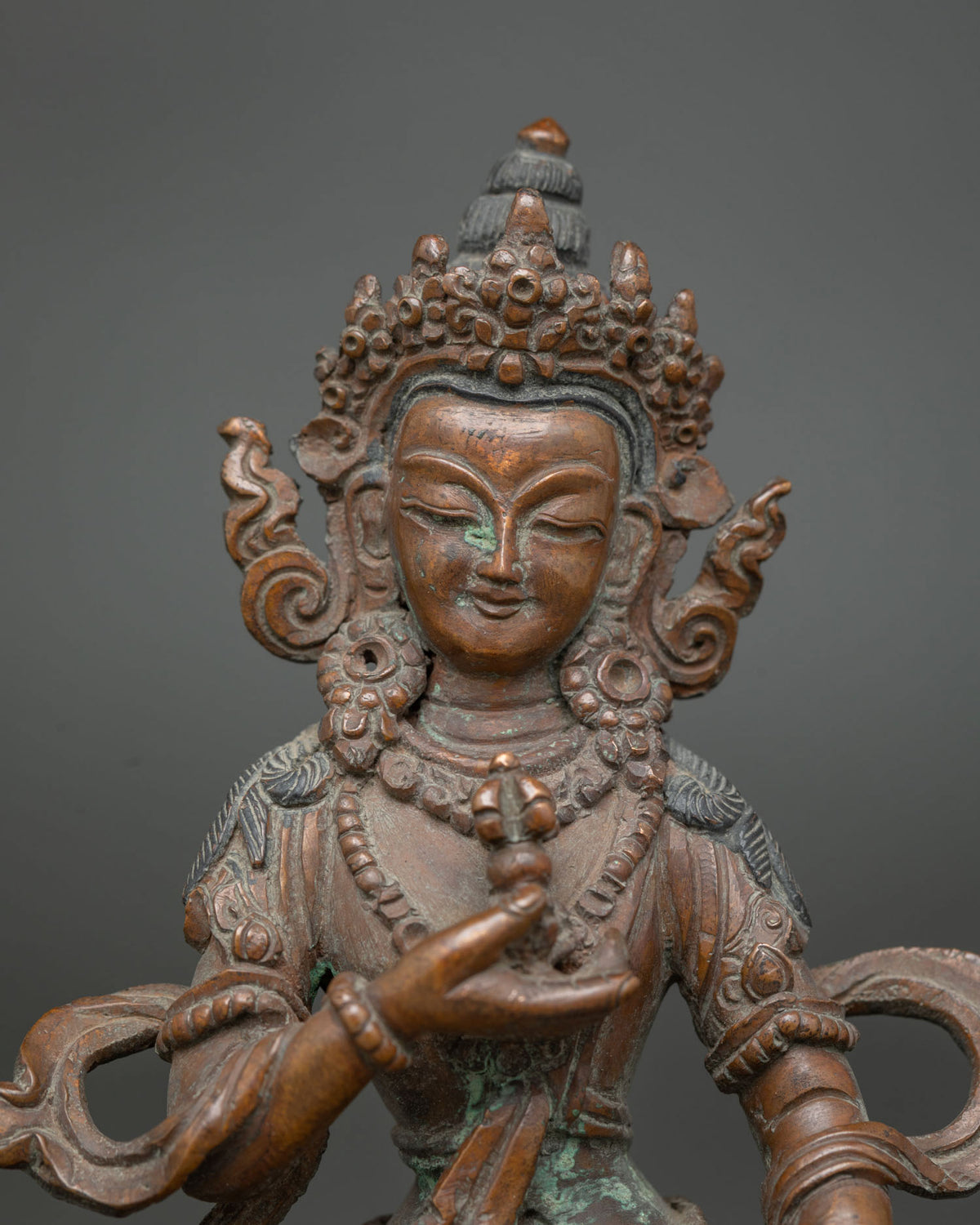 Vajrasattva statue serene expression jeweled crown close up.