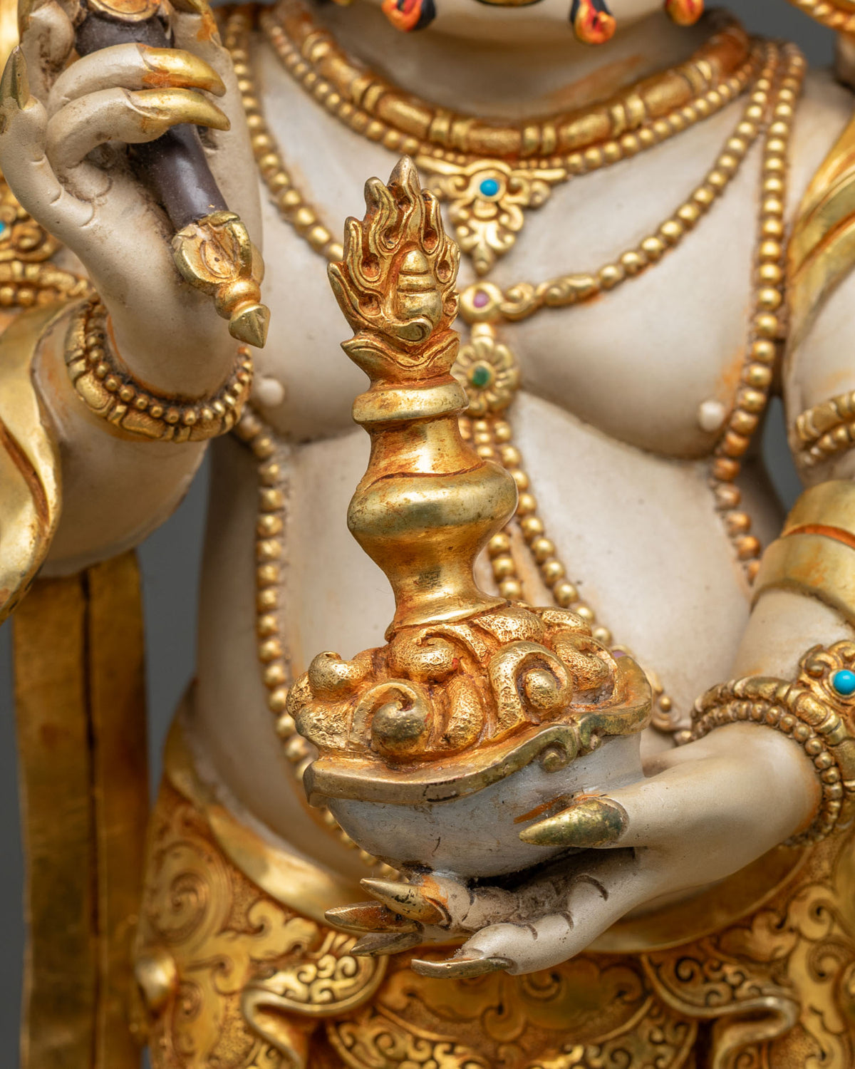 White Mahakala hand holding a skull cup with wish-fulfilling jewel, gold gilding and acrylic colors