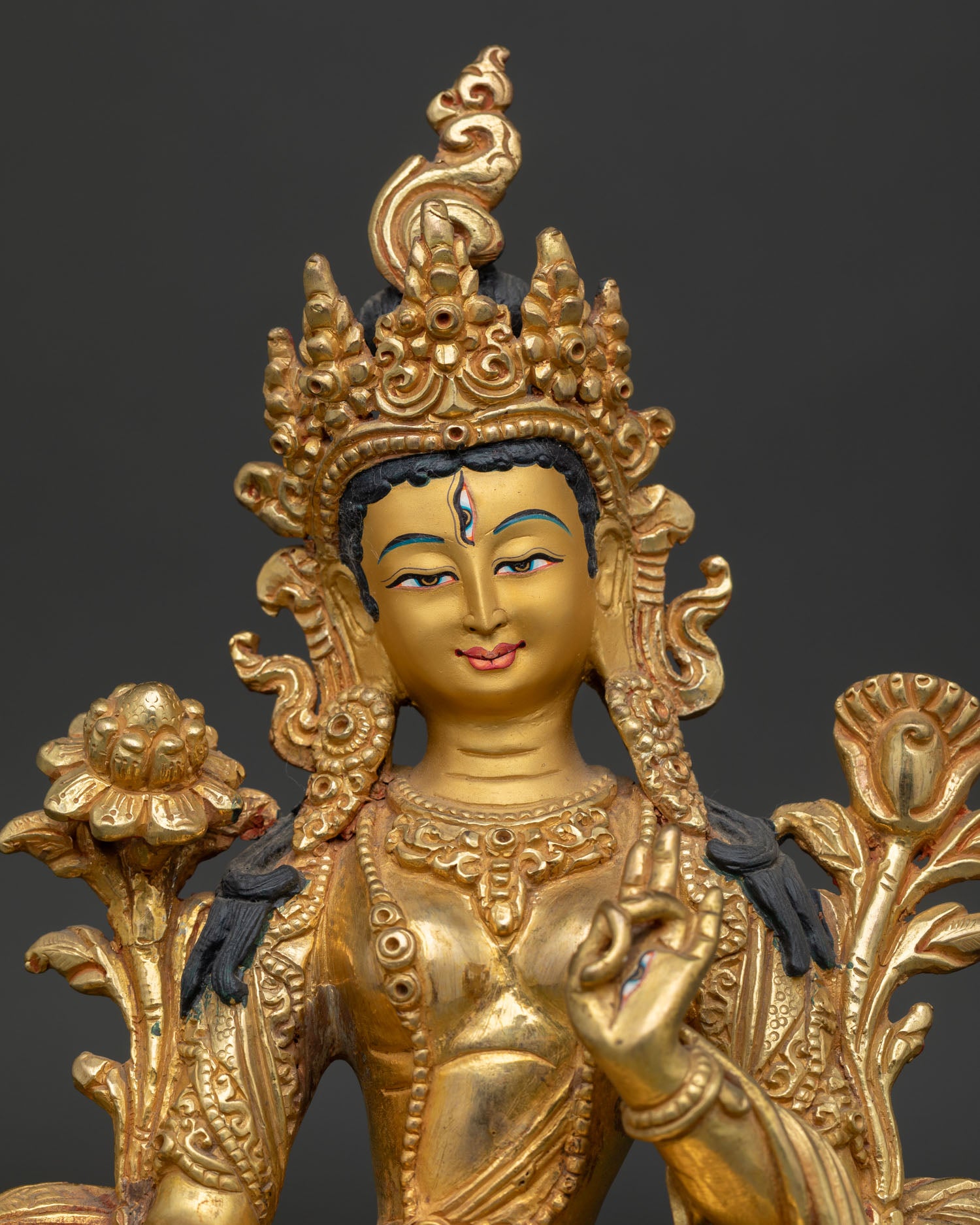 White Tara Buddhist statue with seven eyes and gold painted face.