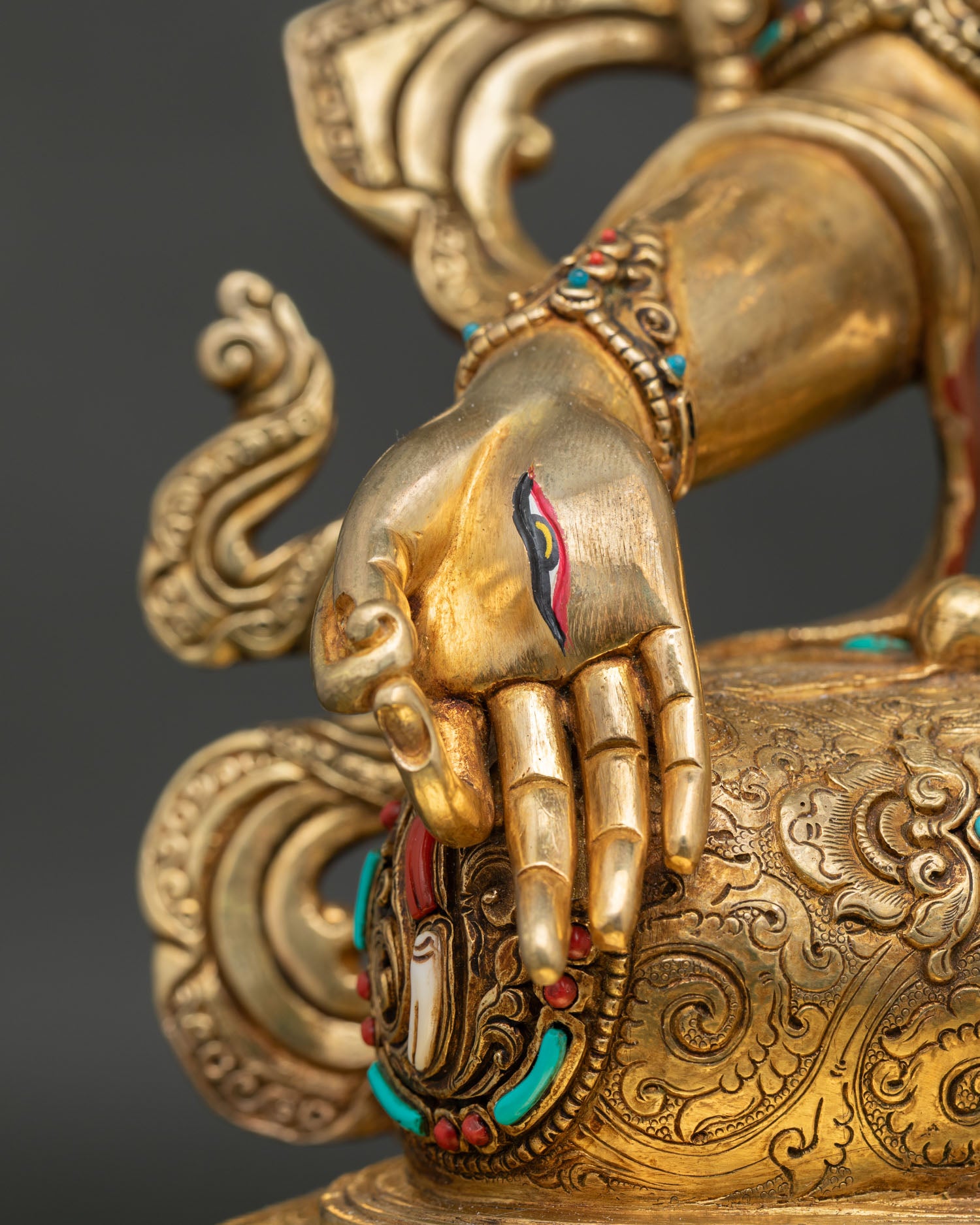White Tara lowered hand detail with symbolic eye and intricate gold-gilded craftsmanship