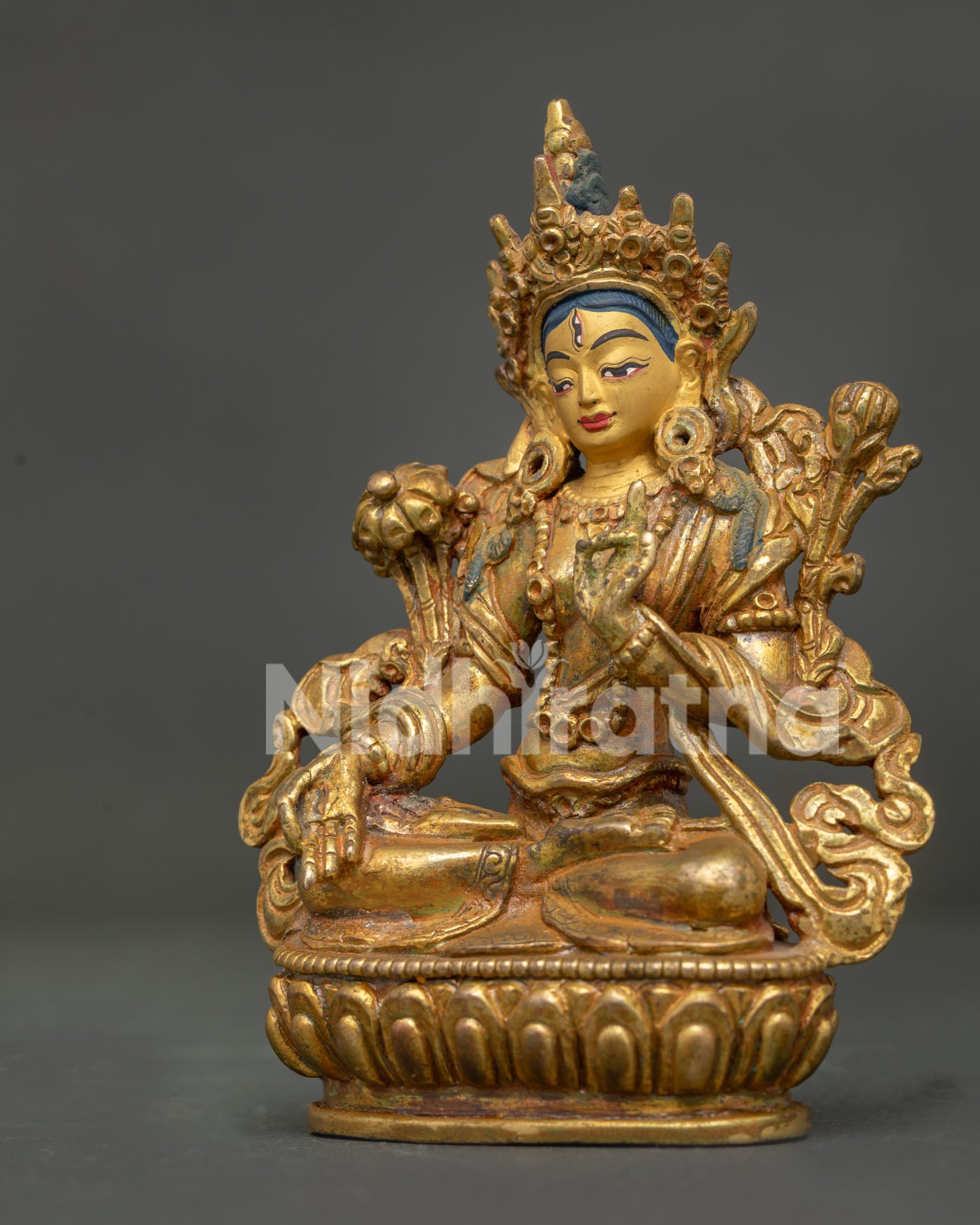 White Tara side view showing flowing robes ornaments and carved floral motifs.