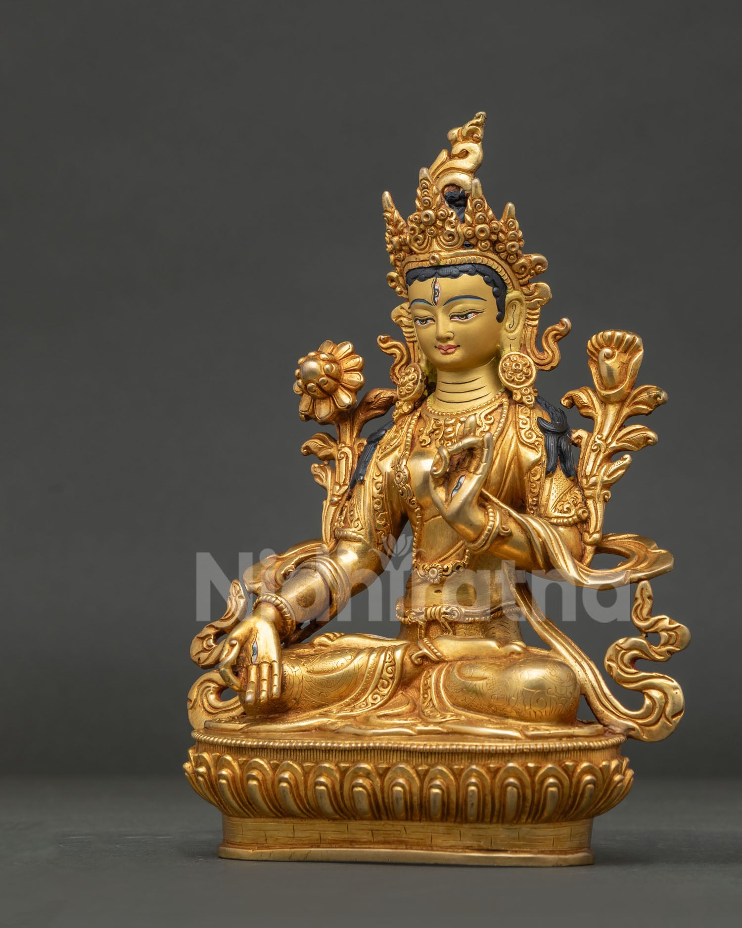 White Tara statue showing seven compassionate eyes and gold fire gilded finish.