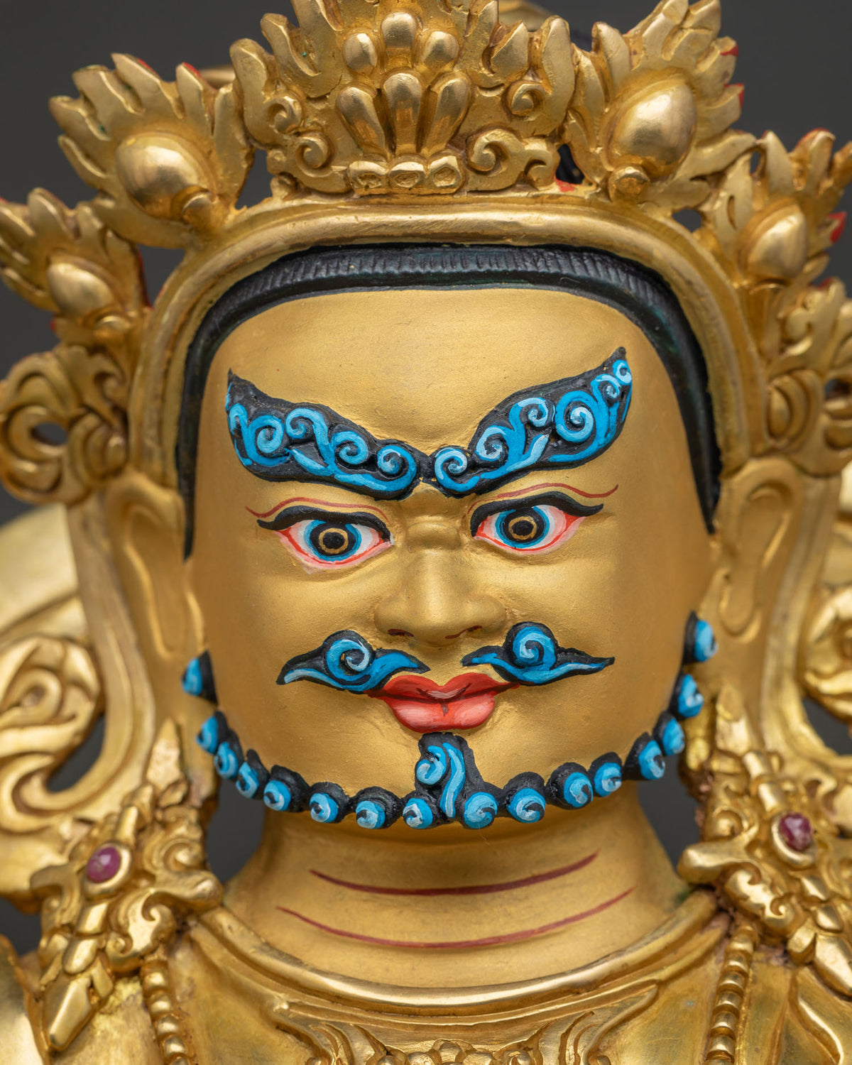 yellow dzambhala face detail 24k gold painted yellow dzambhala statue close up