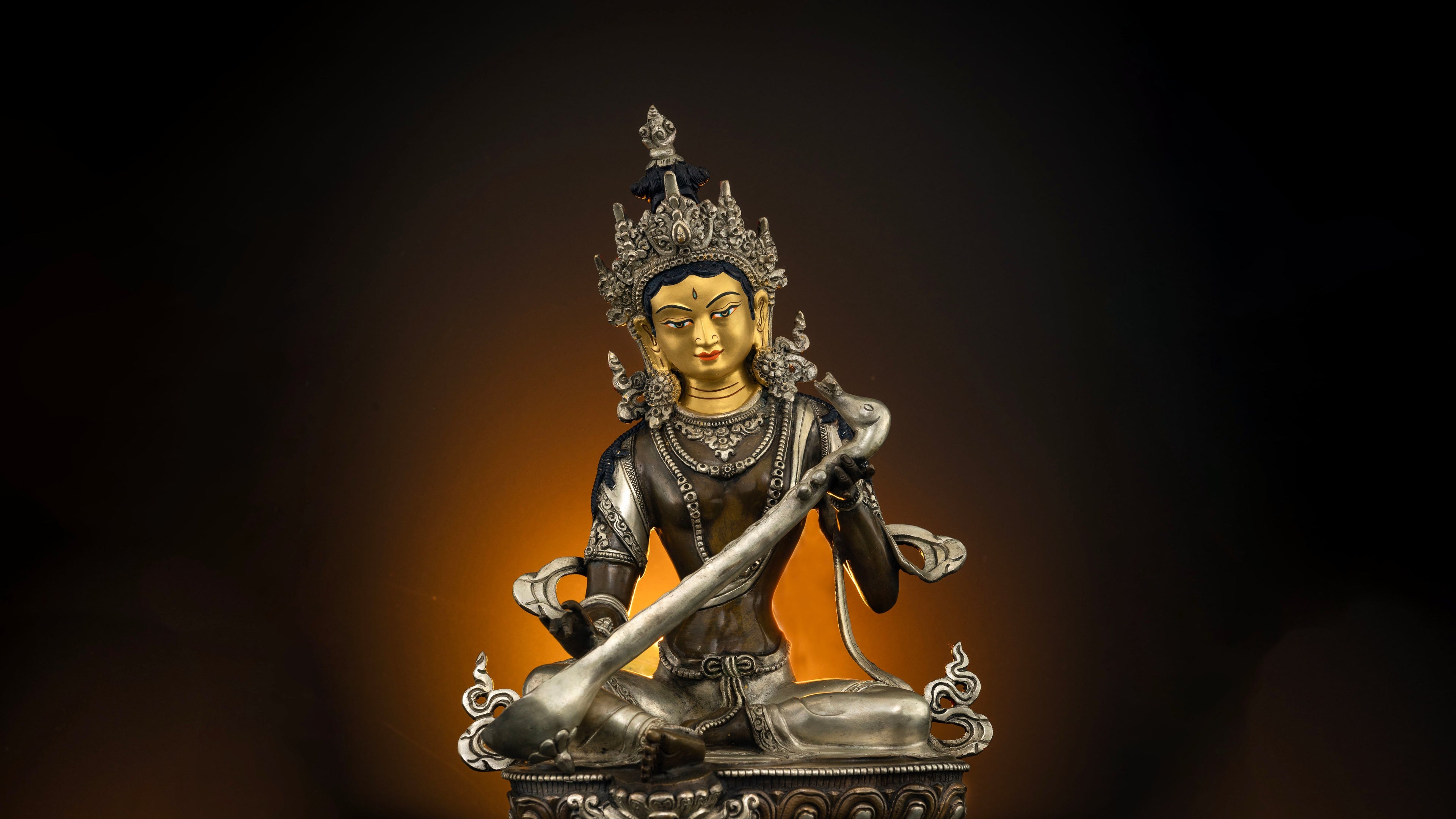 dark brown oxidized copper statue of saraswati with pure gold plated face and silver accents