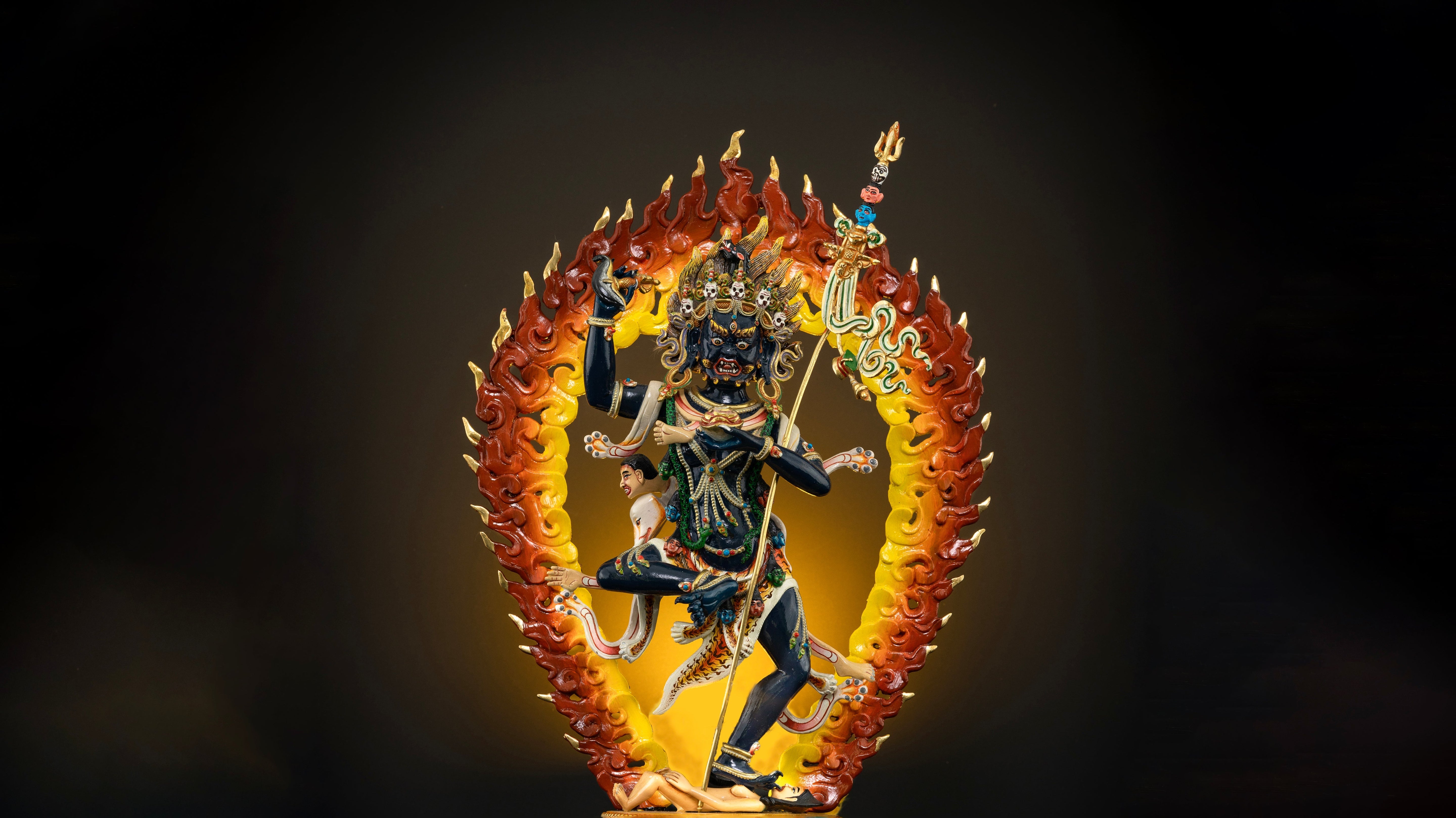Fierce Troma Nagmo statue in a dancing position with a fire halo at her back