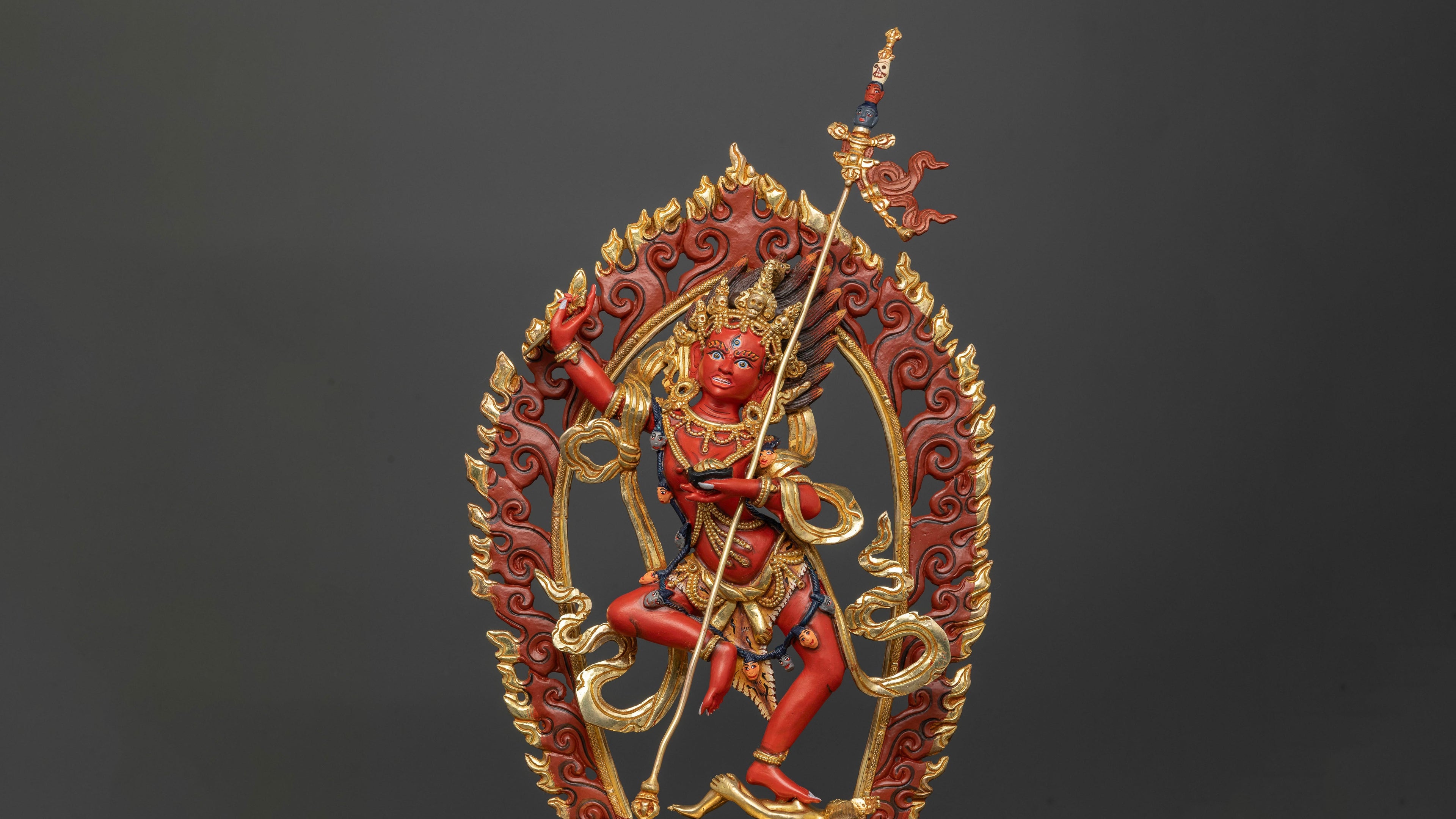 Bright red Dorje Phagmo statue with bright golden accents adorned with semi precious gemstones