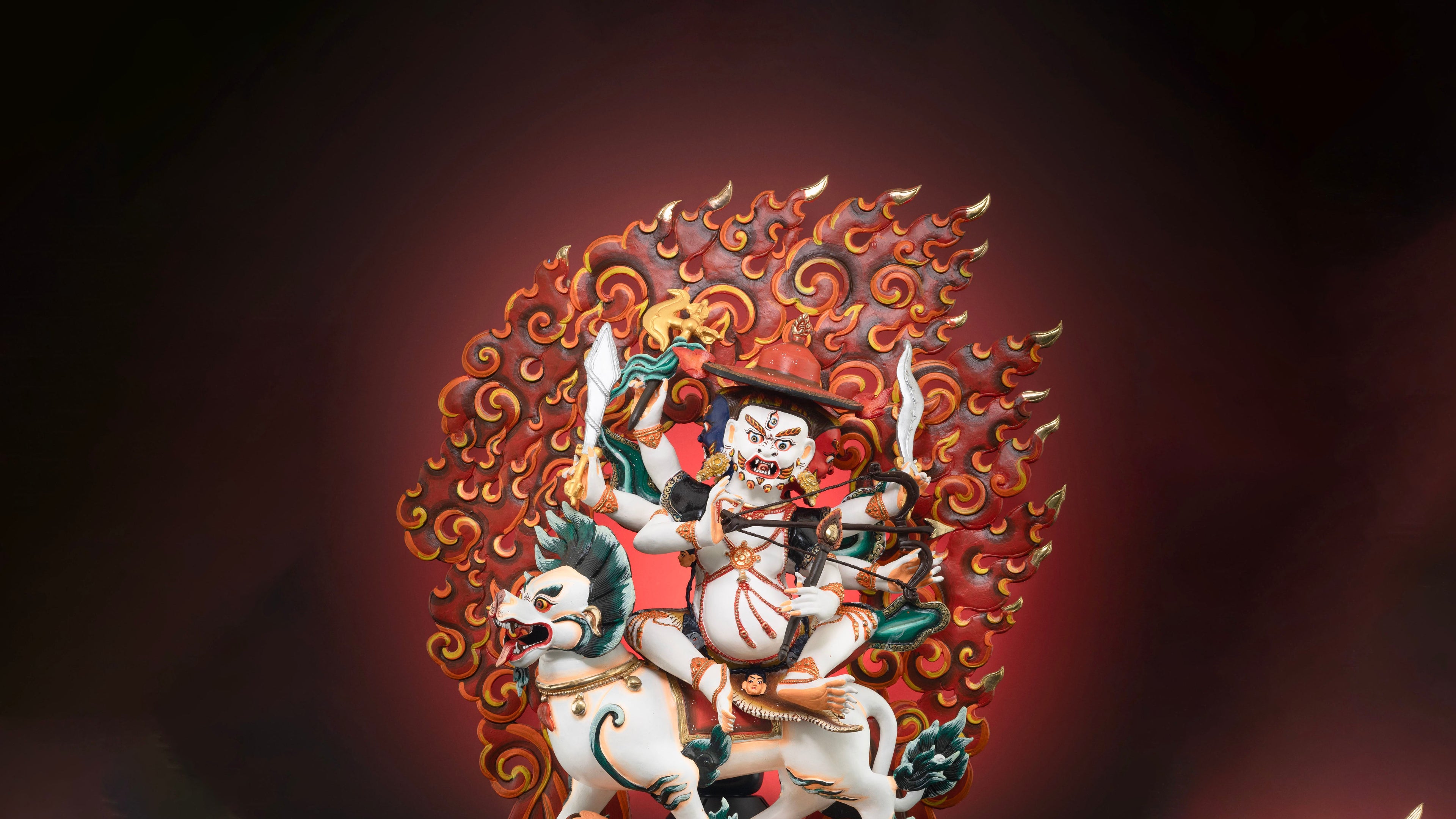 White skinned Pehar Gyalpo statue with red fire background. his mount is also white in color