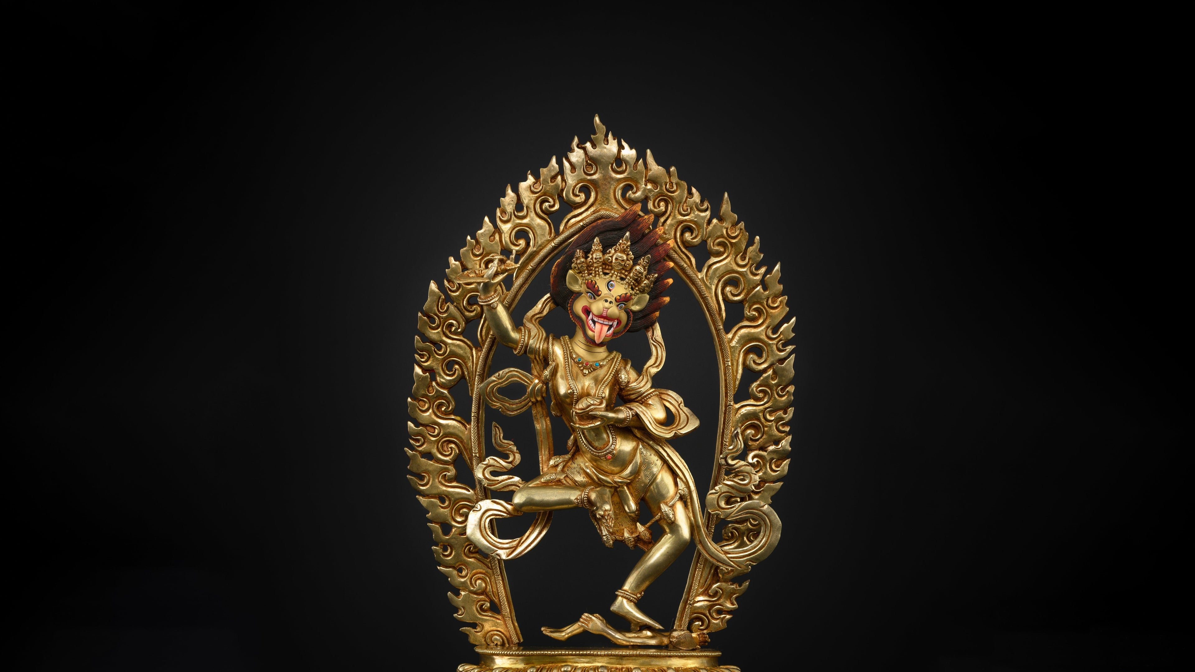 golden dakini statue, which is a buddhist statue with a dark background which is a good fit for religious altars and home decor