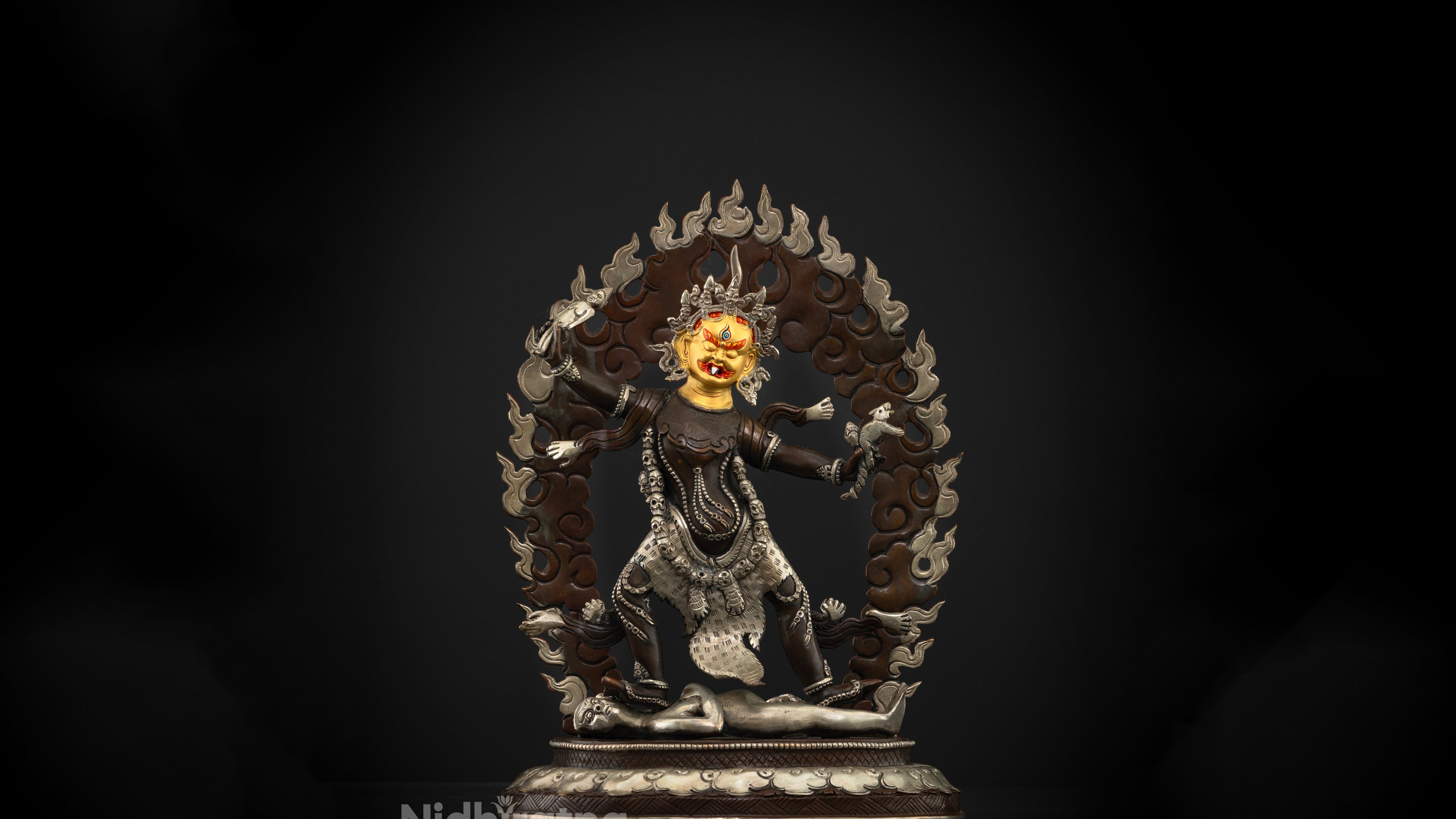 Brown Oxidized statue of Ekajati with silver accents on her fire, jewellery and clothes. she has a pure gold plated bright golden face 