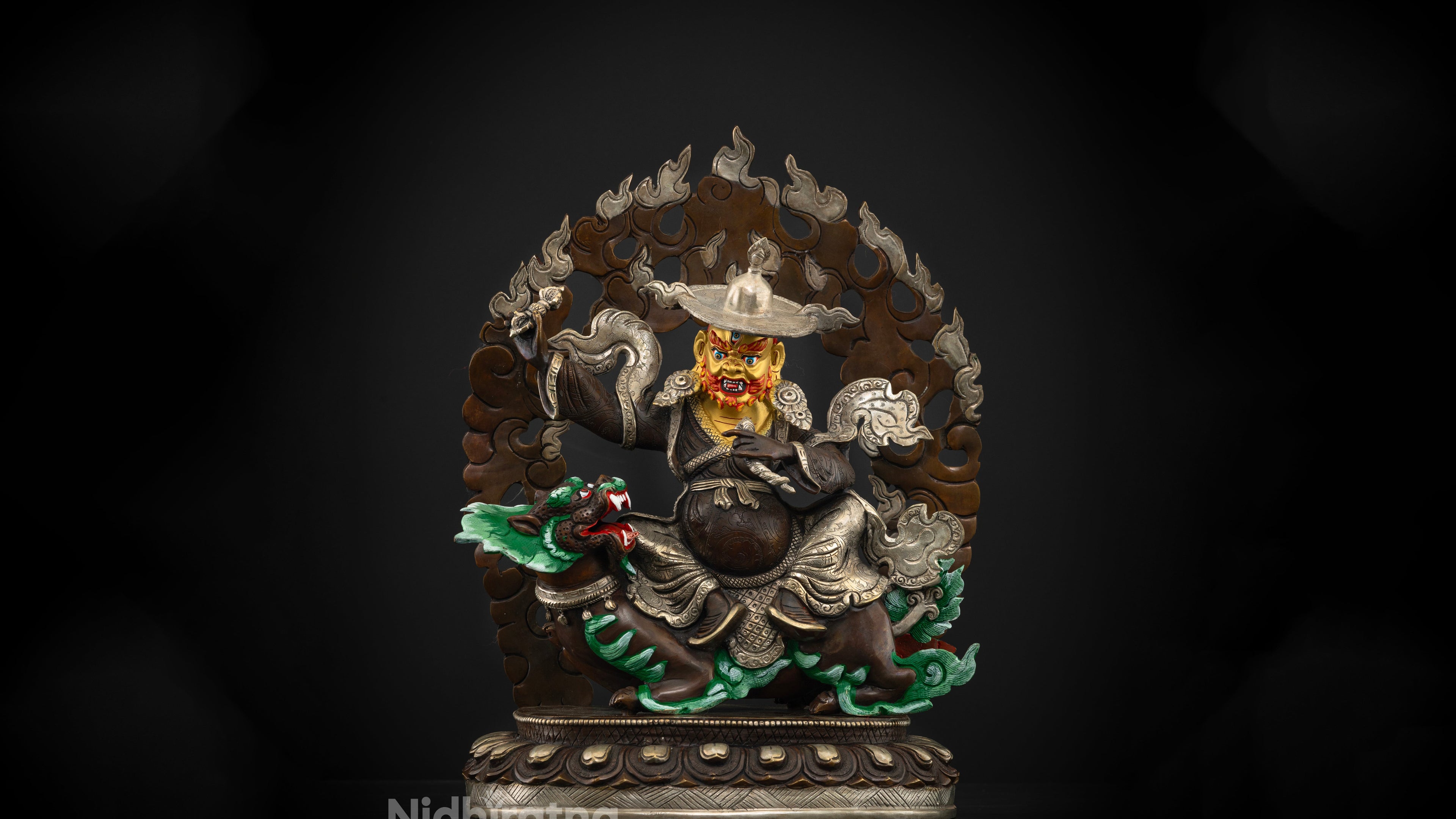 Dorje Drolo statue made of oxidized copper with a pure golden face riding on his steed with a dark black background