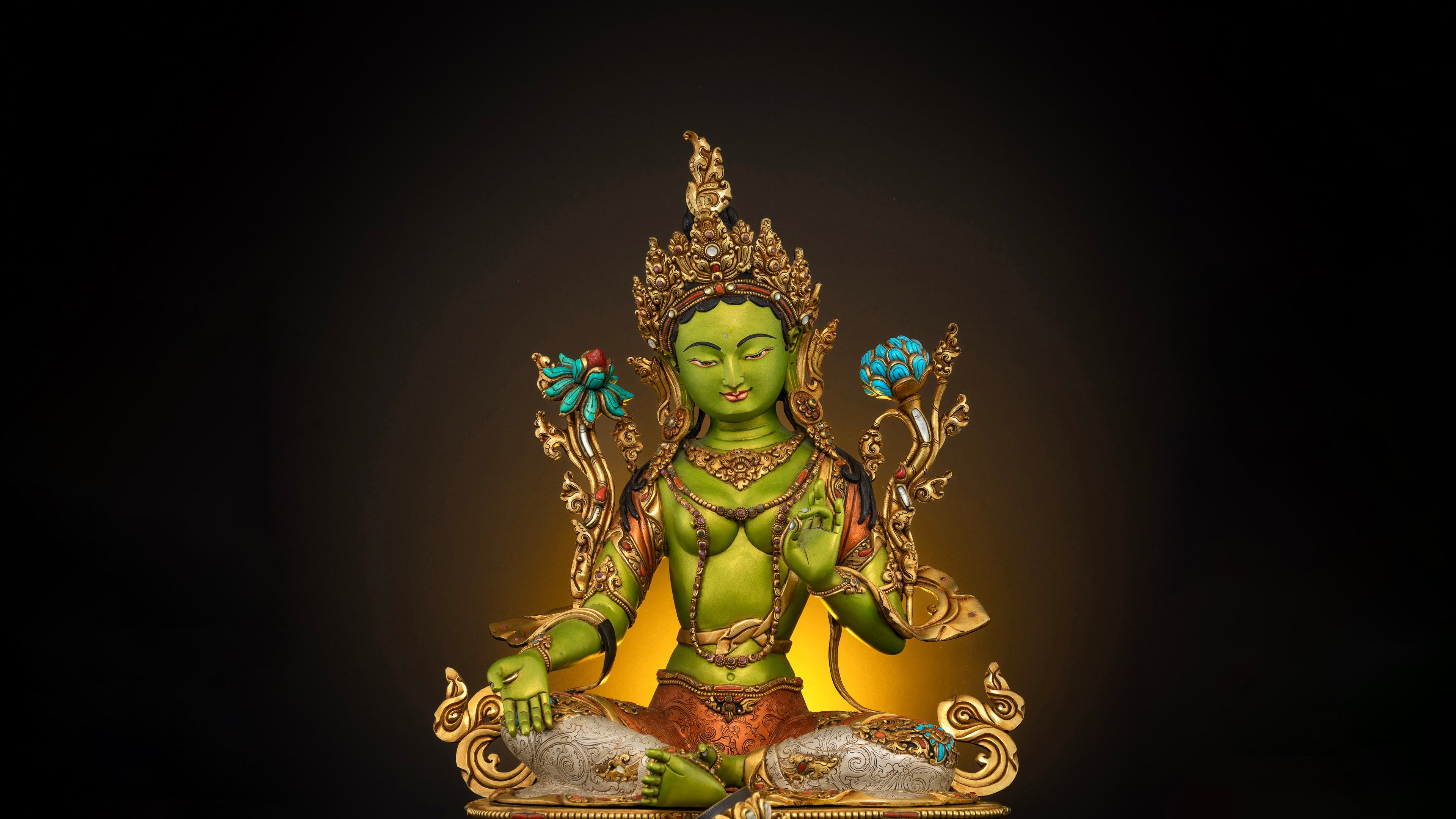 a bright grass green colored statue of green tara with golden crown, robes and other ornaments. Some gemstones are embedded on the statue to give it a even better look