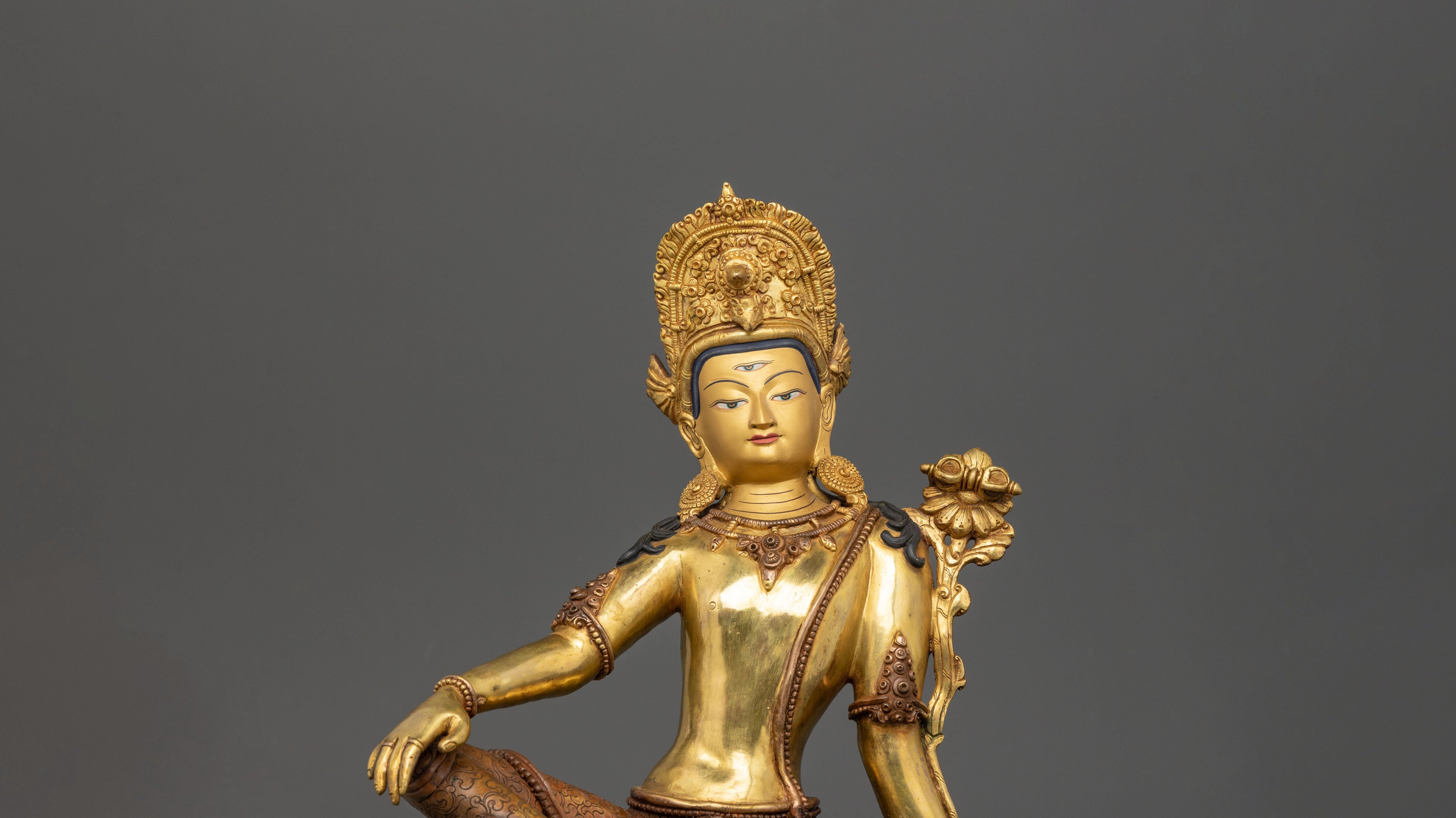 Gold plated Indra statue with intricate carvings sitting gracefully on the floor