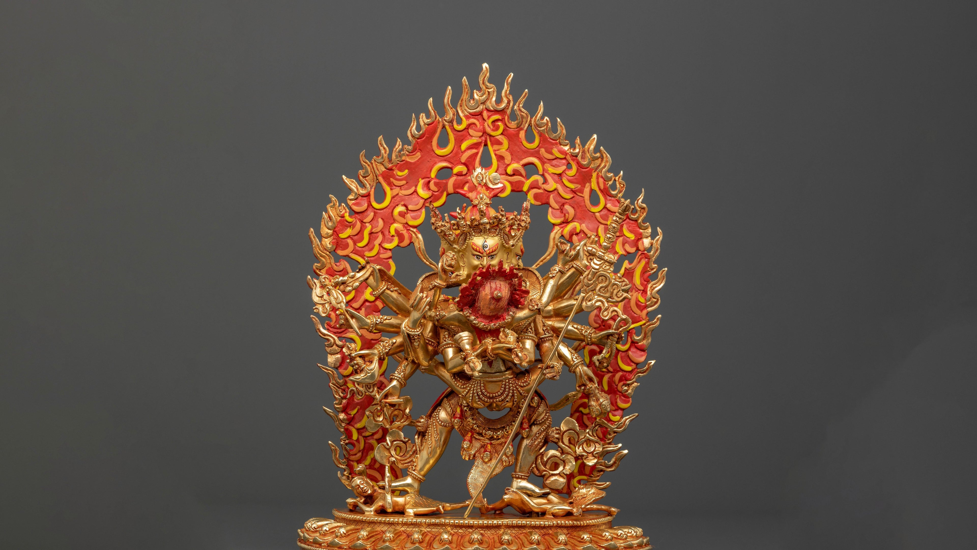 Fierce Kalachakra statue with his consort has intricate detailing and has a orange fiery backdrop