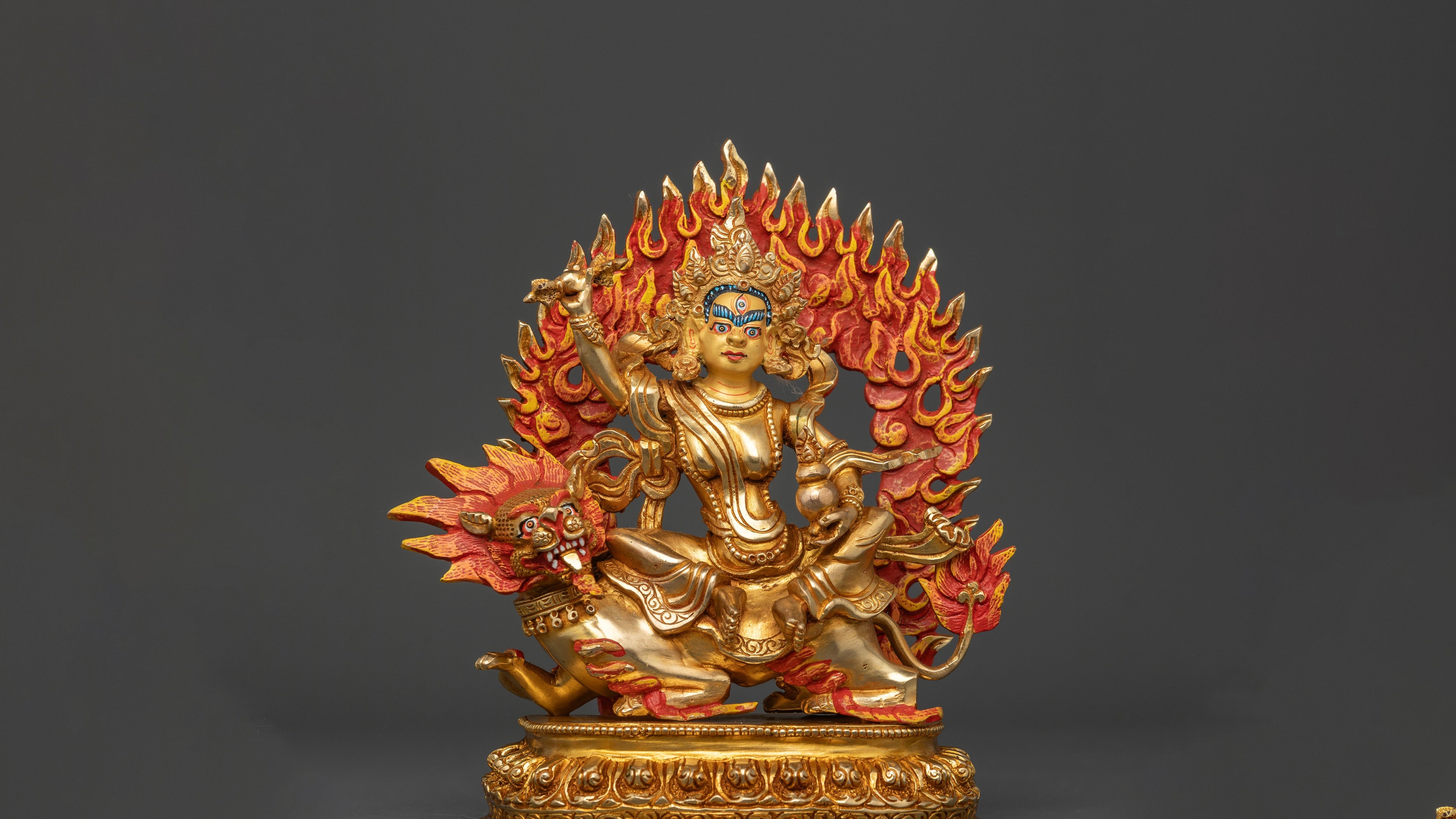 gold plated statue of Tsheringma on her steed and with a red orange fire at her back