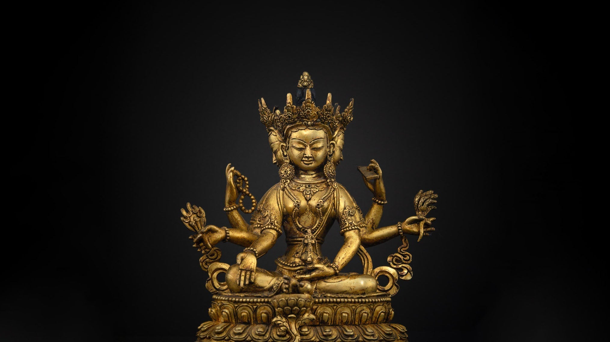 golden statue of Vasudhara with six arms and three faces