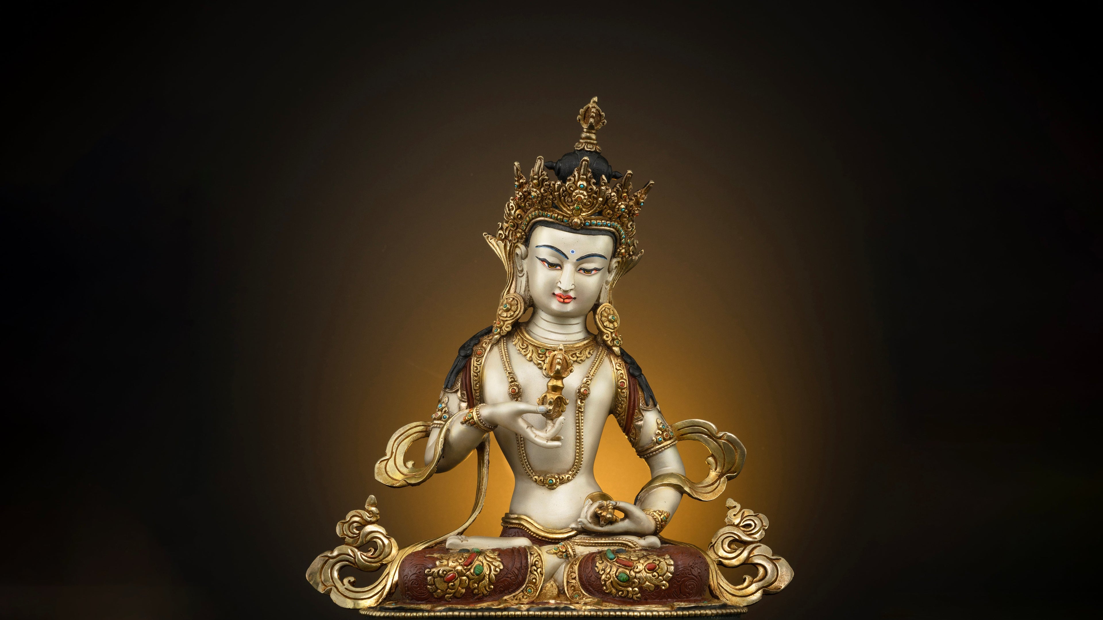 white skinned vajrasattva statue with golden robes, jewellery and crown