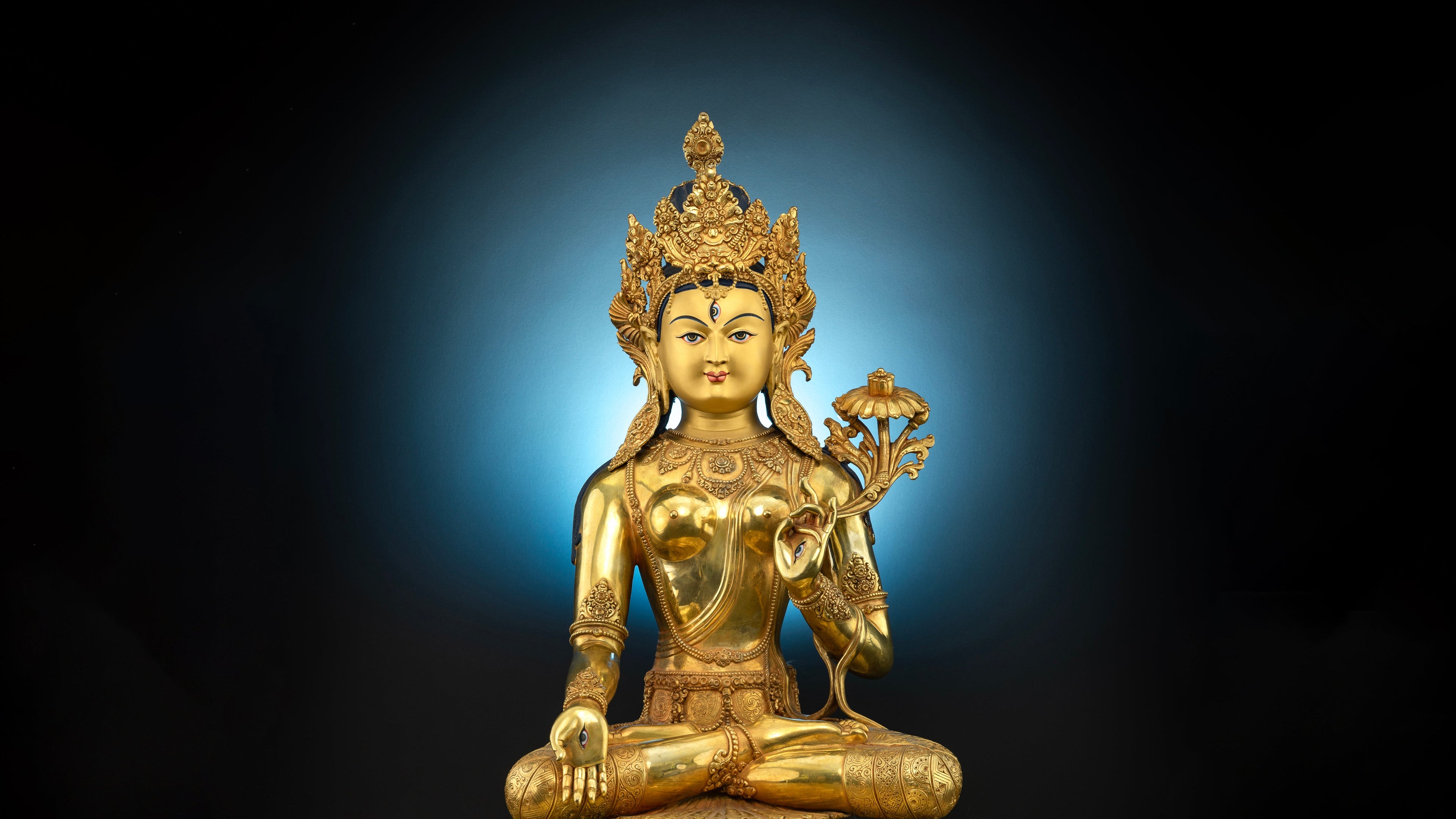 gold plated statue of white tara with intricate detailing and adorned with gemstones