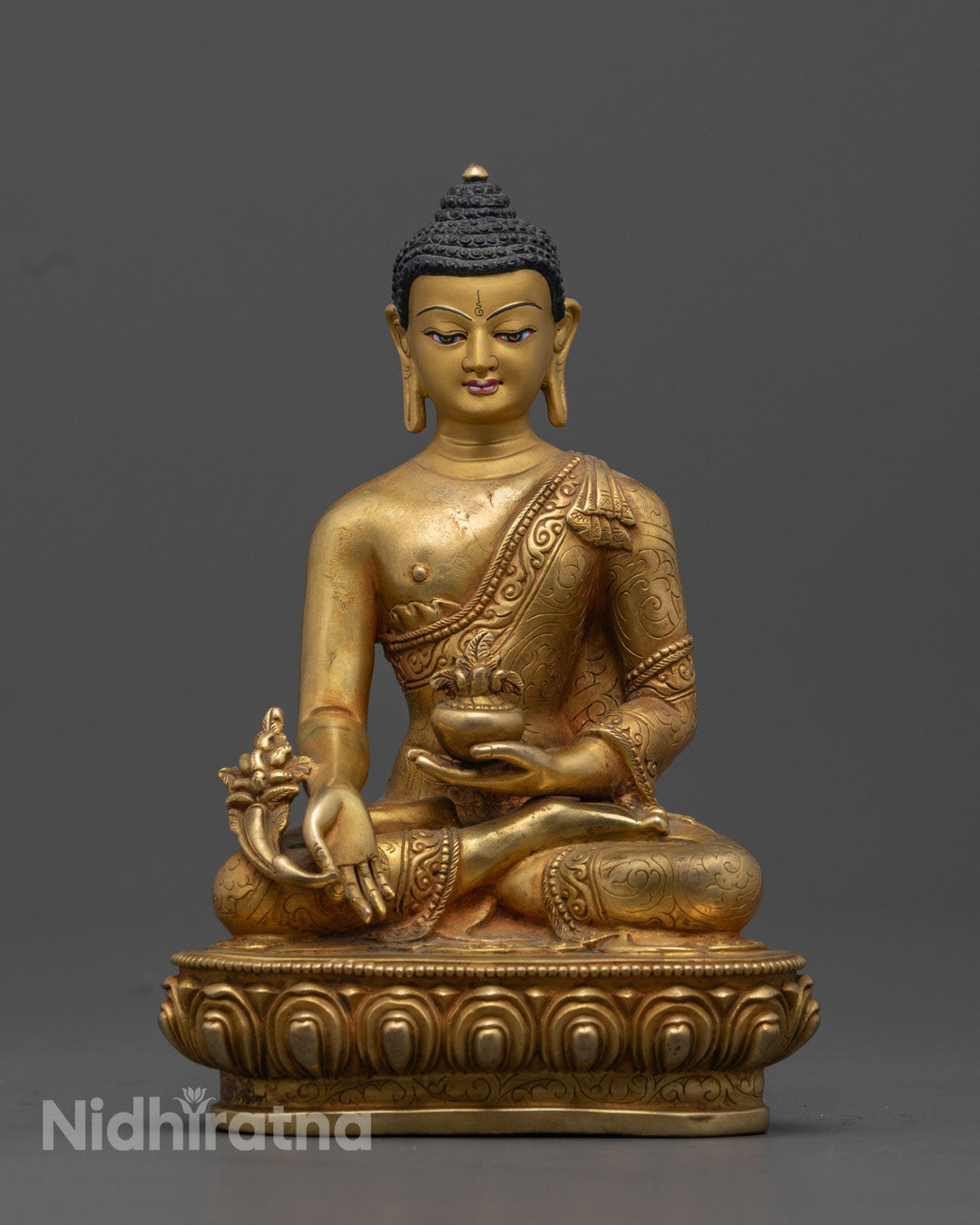 24K Gold-Gilded Medicine Buddha Statue handcrafted by Nepalese artisans, showcasing intricate robe carvings, with the Buddha holding a myrobalan plant in the left hand and a vessel of medicinal nectar in the right, seated on a lotus throne