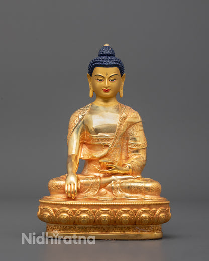 A machine-made 24k gold gilded copper statue of Shakyamuni Buddha seated