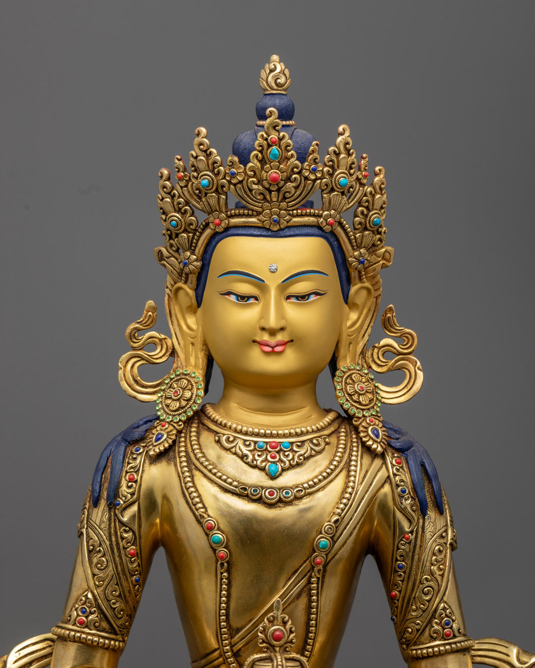 Amitayus Buddha’s serene face and ornate crown, highlighting the detailed turquoise and coral decorations on the beautifully crafted.