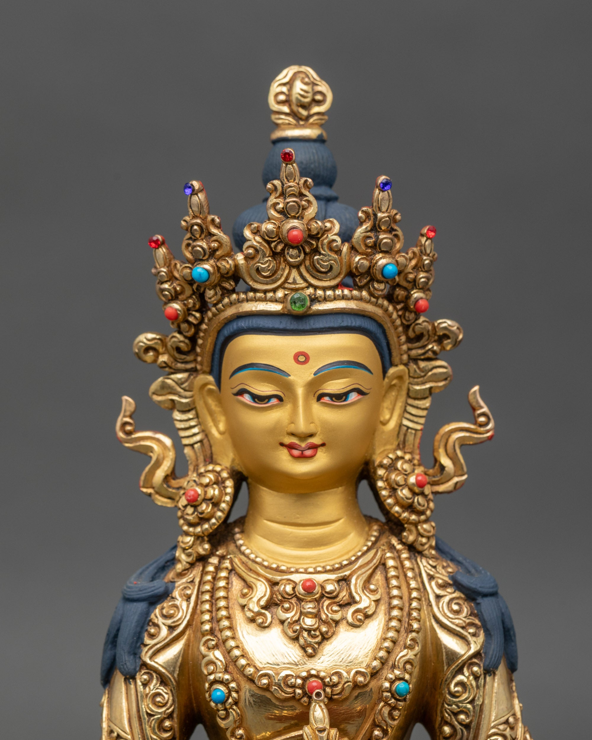 Amitayus Buddha statue close-up, serene expression, gold fire-gilded surface
