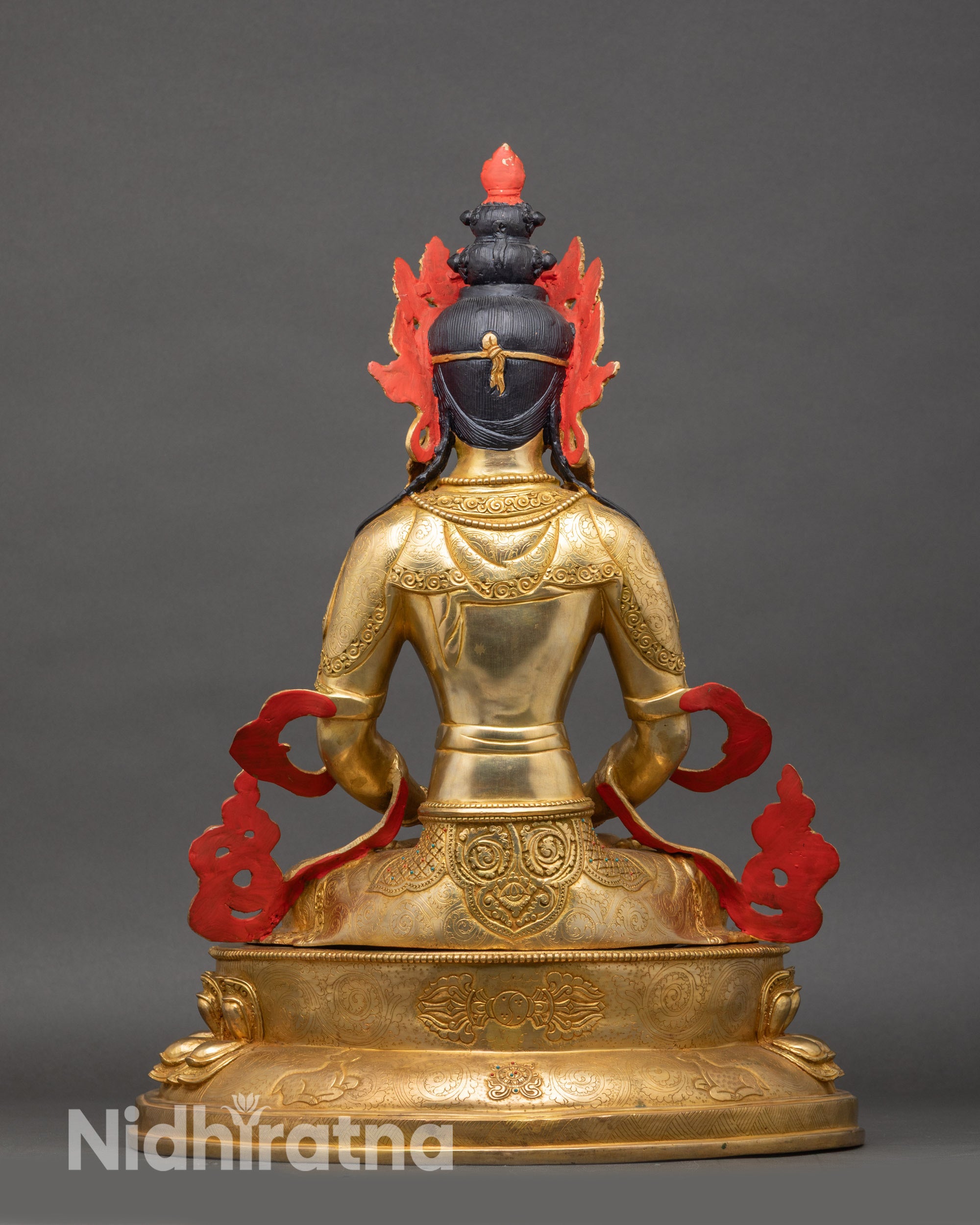Back view of Amitayus statue, engraved lotus pedestal and flowing monastic robes