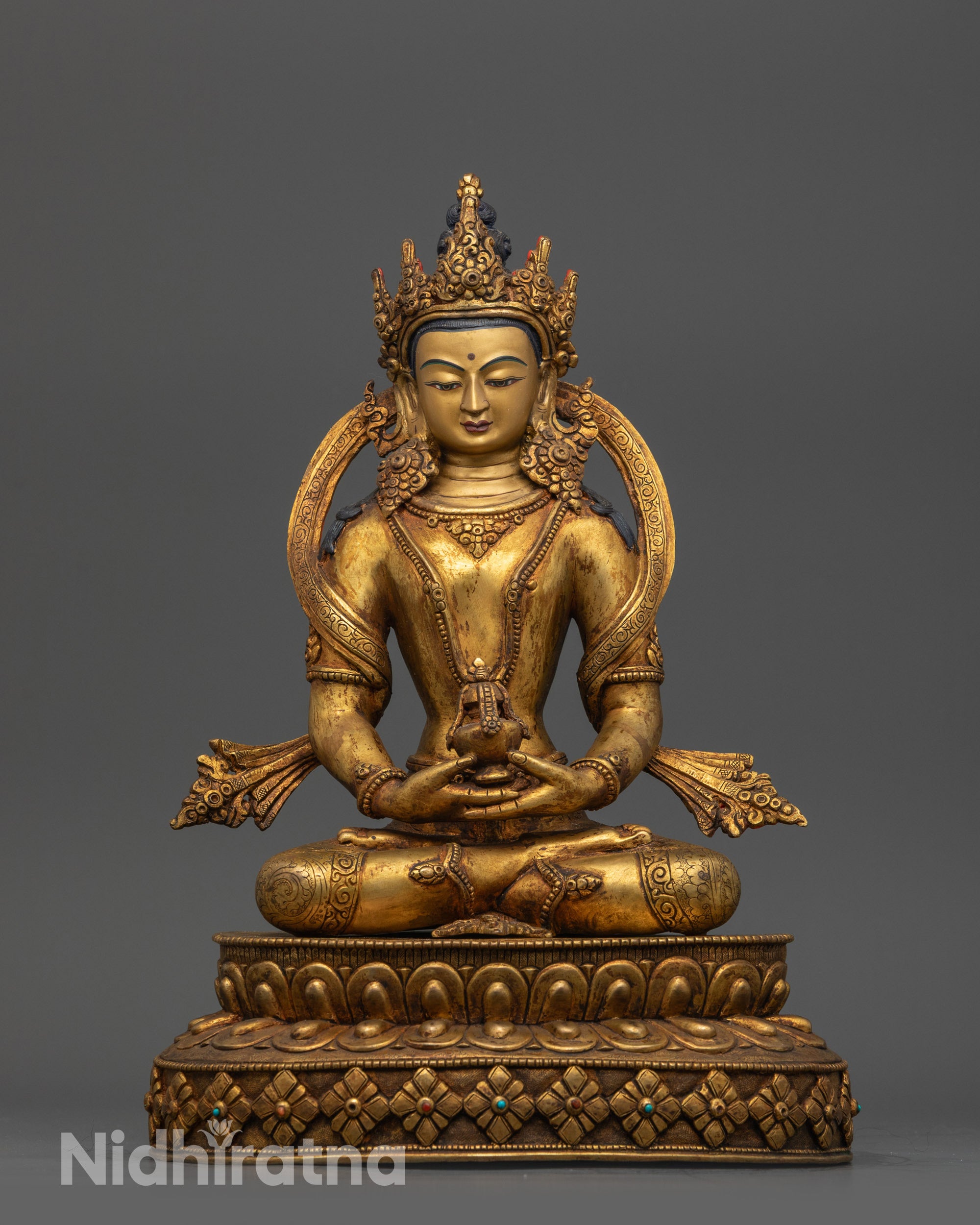 Angled view of Amitayus seated on lotus with gold-gilded face and ornate jewelry