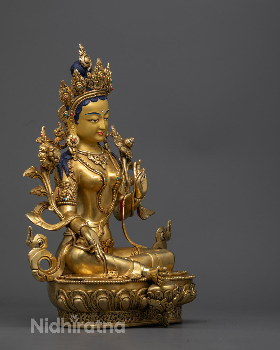 Artisan from Nepal skillfully crafting the Green Tara Statue using the traditional lost wax method in a workshop setting.