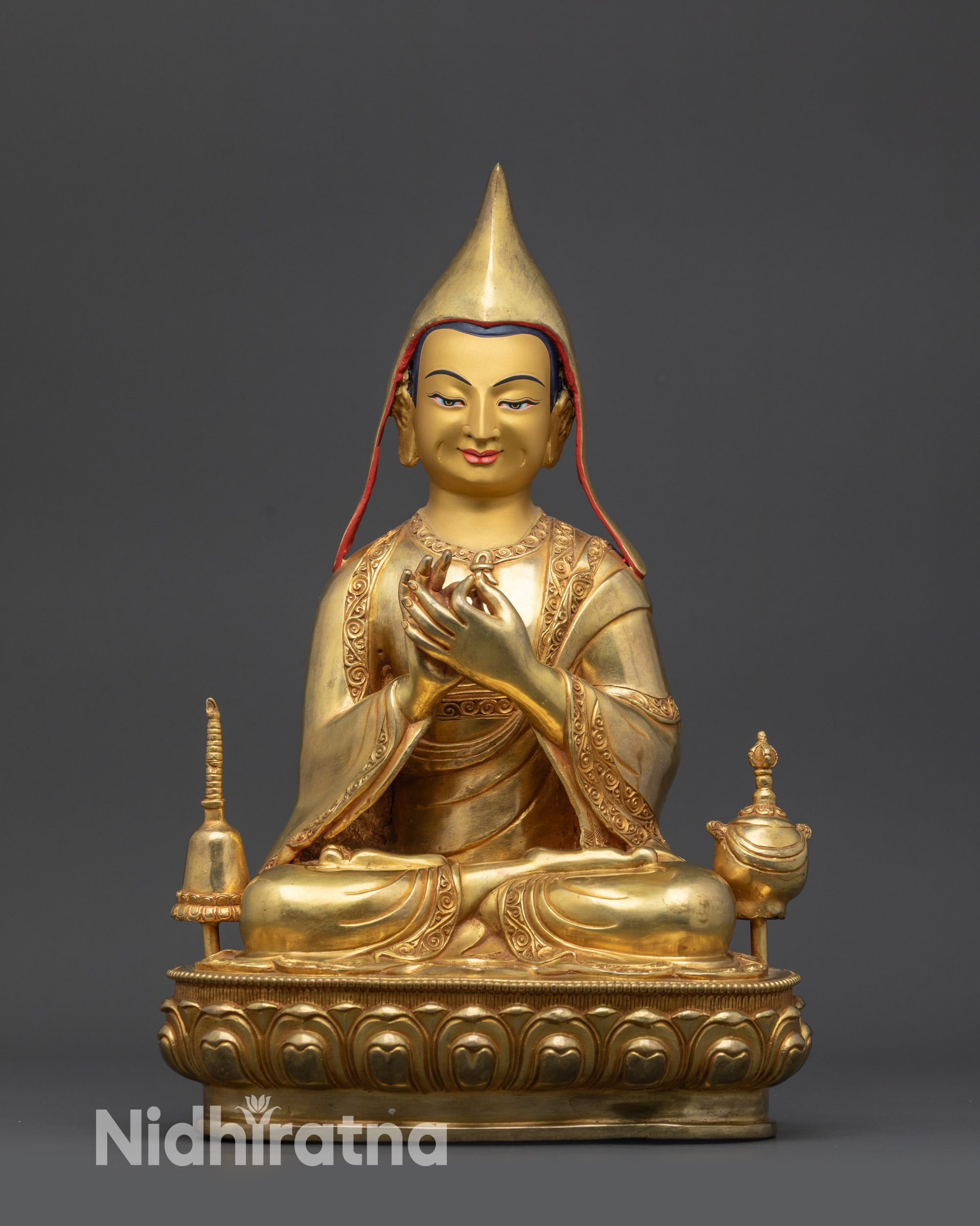 Atisha statue front view on lotus seat with gold-gilded base and ornate carvings
