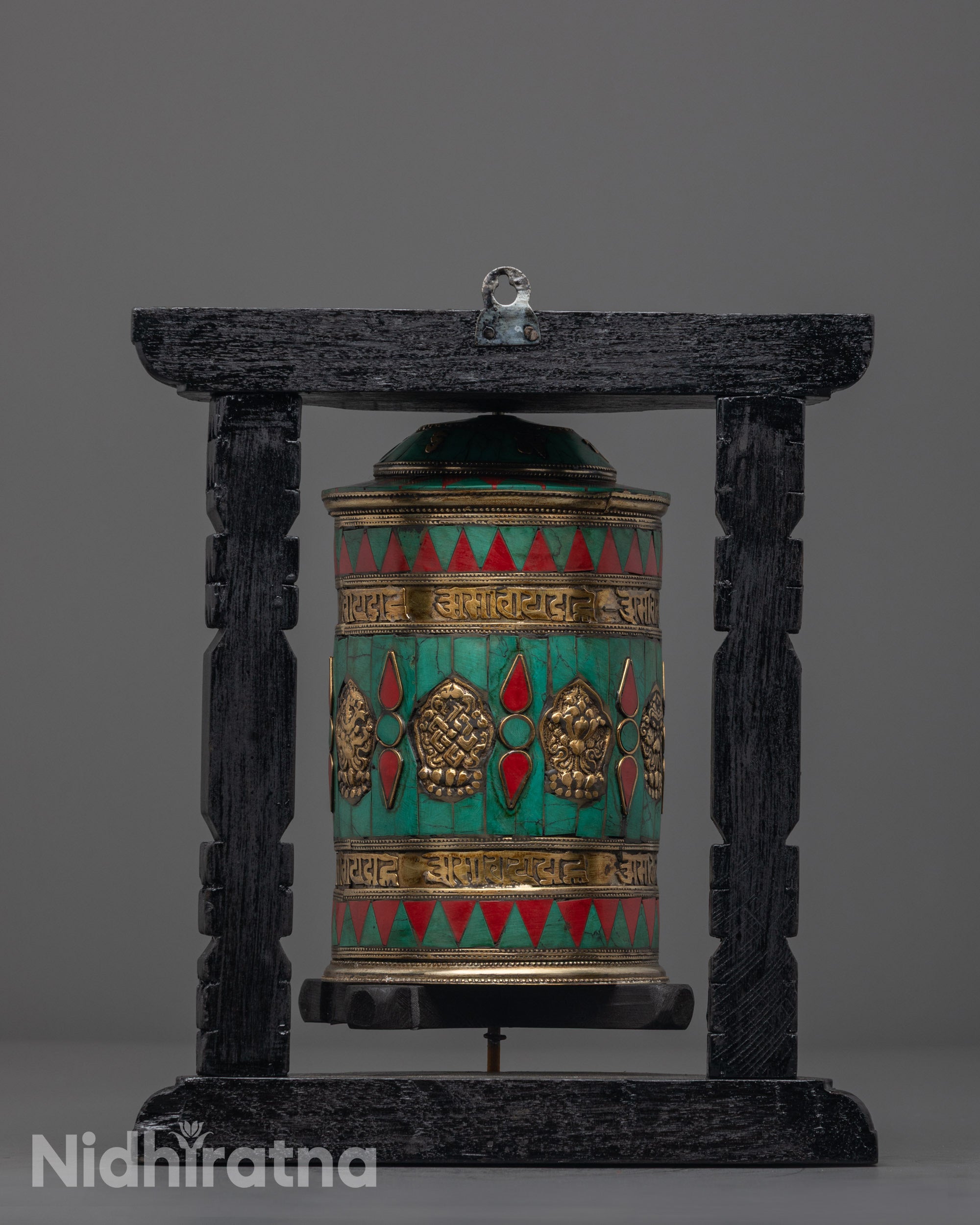 Auspicious Prayer Wheel placed on shrine with dark wood frame, copper body, and sacred Tibetan symbols