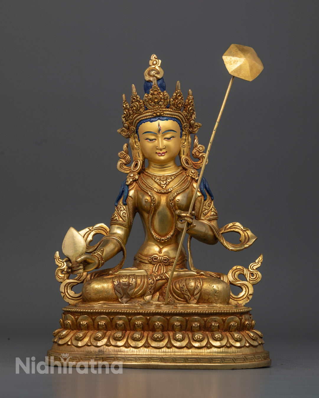 Authentic Dukar statue handcrafted in Nepal featuring detailed carvings on robe crown and jewelry holding utpala flower and parasol symbolizing peace and protection.
