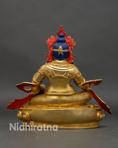 Back view of Dzambhala statue, showing carved lotus pedestal and ornate relief patterns
