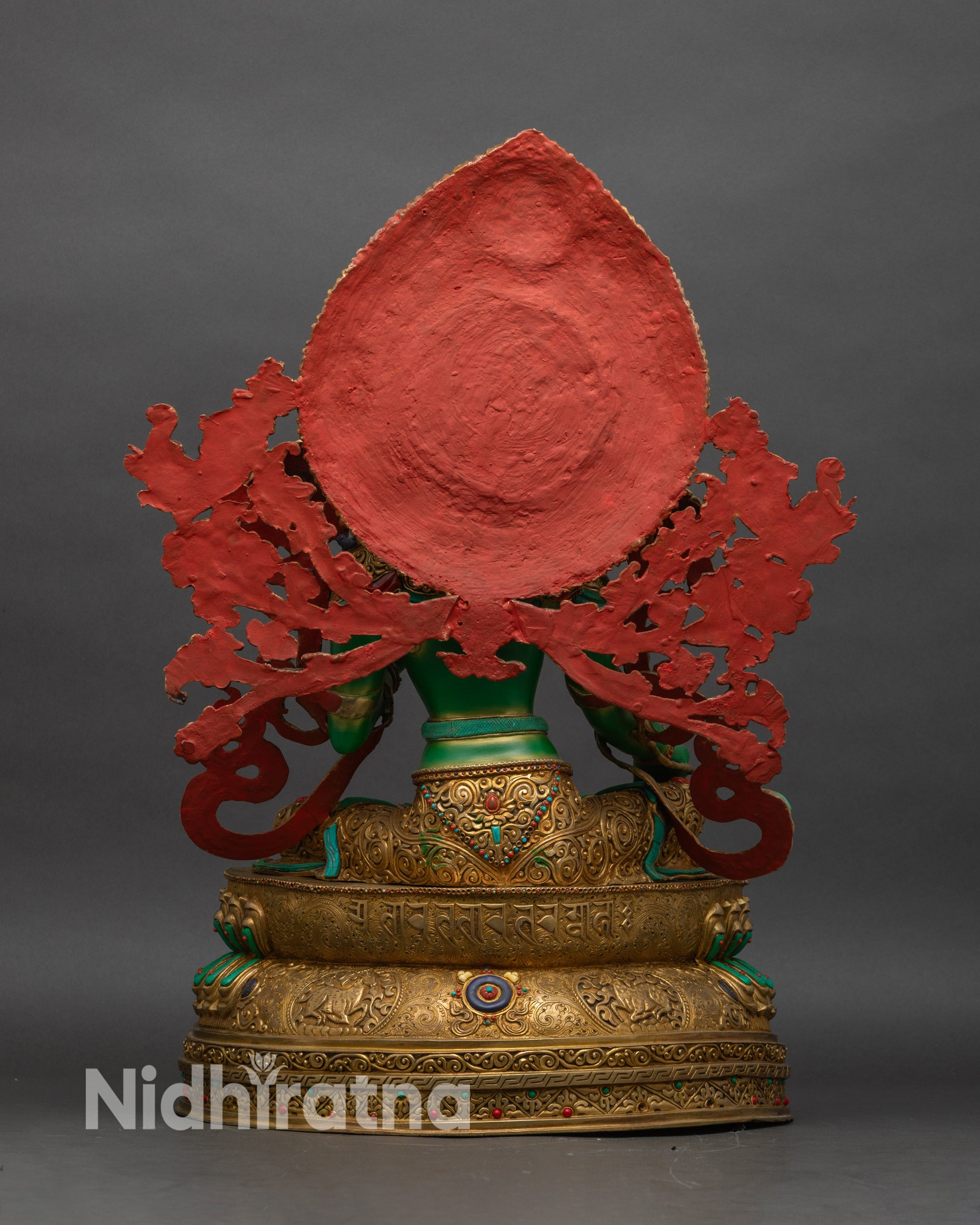 Back view of Green Tara statue showing lotus pedestal, mandorla halo, turquoise inlays