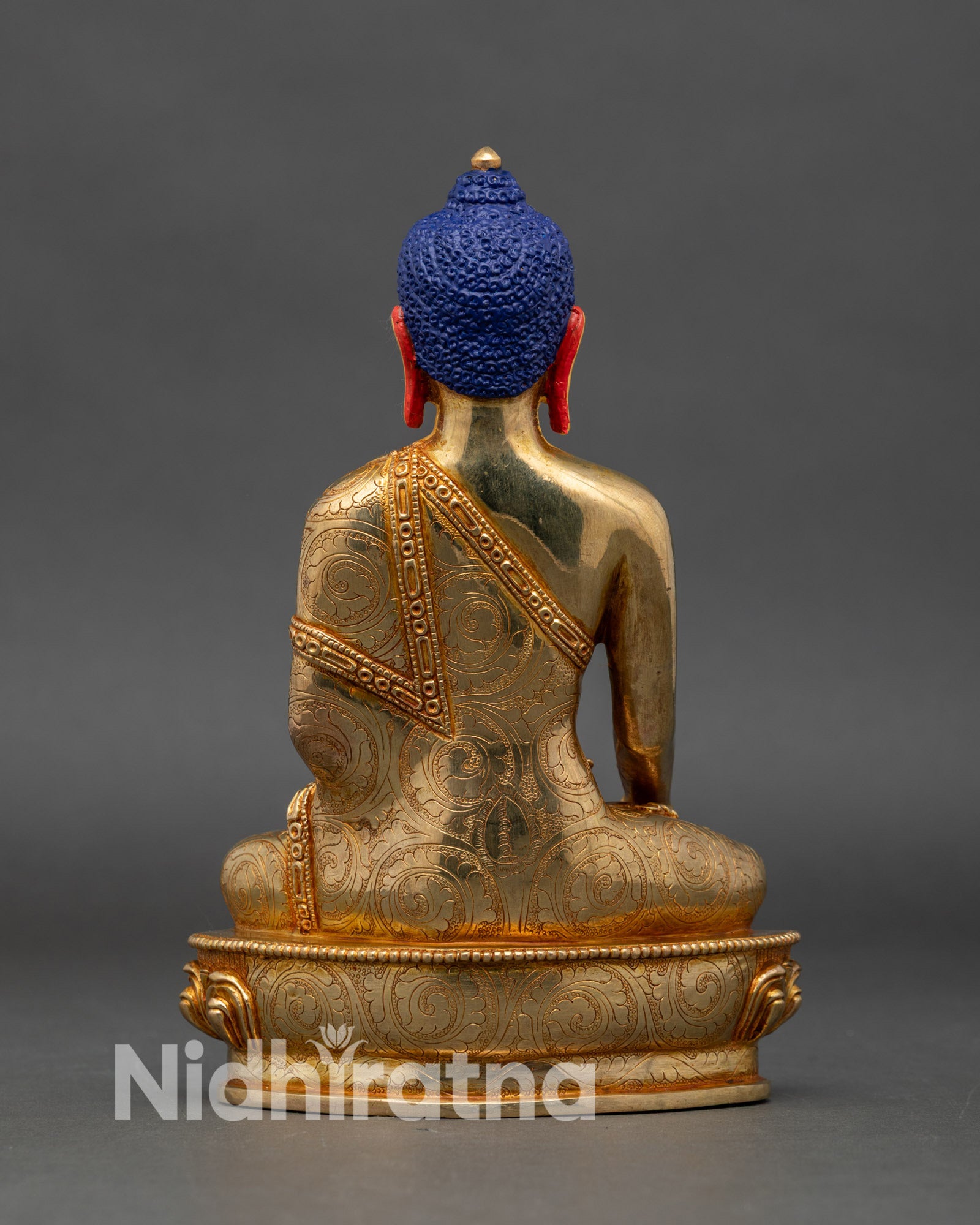 Back view of Shakyamuni Buddha statue, intricate floral robes and lotus pedestal copper gold